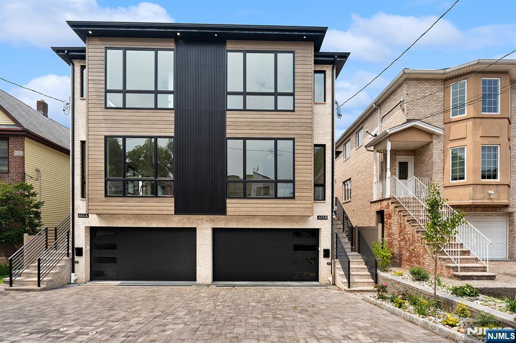 Welcome to 465B 1st Street in Palisades Park, an incredible opportunity to own a striking, brand-new home on a premier street where you can walk to both downtown Leonia and downtown Palisades Park. Where luxury new construction meets an unrivaled location, the main floor welcomes you with a completely open layout, bathed in natural light from massive windows, featuring a spacious living room with a fireplace and custom built-ins, a powder room, and a gorgeous eat-in kitchen with a waterfall center island, dining area, and sliding glass doors to your private balcony. Upstairs, a dedicated laundry room services three large bedrooms, including a premier primary suite boasting three closets and a spa-like bath with a soaking tub and walk-in shower. The functional ground level offers a two-car attached garage, an entry mudroom, a home office, a full bathroom, and a convenient summer kitchen with a washer and dryer combination that walks out directly to the backyard. Complete with central air conditioning, modern glass stair railings, and custom baseboard molding, this one-of-a-kind property places fantastic dining, vibrant storefronts, and easy NYC commuting options right at your doorstep. Come see today!