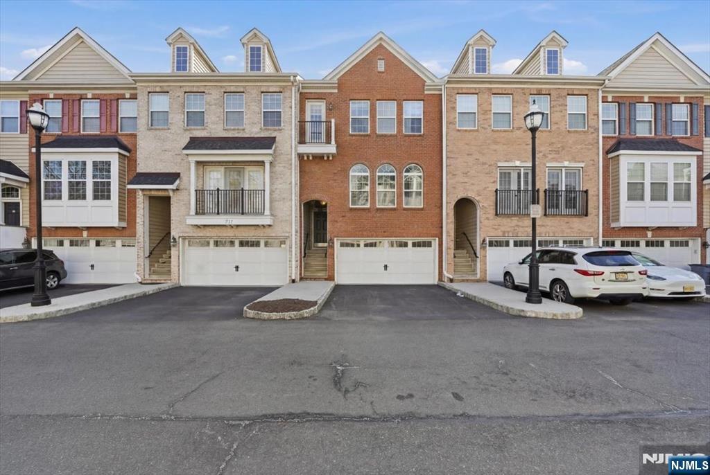 Welcome to this beautifully maintained brownstone-style townhome built in 2008 by Centex Builders, offering approx. 2,369 sq ft across three levels. This spacious home features 3 bedrooms, 2 full baths, and 2 half baths with hardwood floors throughout. The main level offers a bright living and dining area with floor to ceiling window and tray ceiling. In addition, there is a powder room, and an open family room with a gas fireplace leading to a gourmet kitchen with center island, granite countertops, 42â€ cabinets, stainless steel appliances, separate pantry and access to a private deck. Upstairs features a large primary suite with tray ceiling, walk-in closet with custom organizers, and en-suite bath with jetted tub, separate shower, and double vanity. Two additional bedrooms, full bath, and laundry room complete the level. Ground floor includes a versatile recreation room/office with a half bath and access to another private patio. Enjoy unobstructed meadow views, an oversized garage, and double driveway. Dual-zone HVAC with smart home with Nest thermostats and primary bedroom lighting. Low taxes & HOA. Convenient to NYC transportation & free shuttle to train station, schools, parks, shopping, and dining.