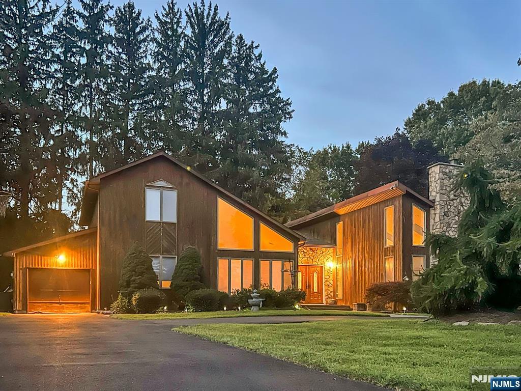 This exceptional South facing 4 bdrm, 3 bath contemporary residence is tucked away on a peaceful cul-de-sac, offering a perfect blend of style, and comfort. A wraparound driveway leads to a welcoming entry foyer that sets the tone once you step inside. The home has been thoughtfully updated with brand-new hardwood floors, new interior doors, fresh paint, new recessed lighting, new furnace and hvac system. The expansive living room is filled with natural light from floor to ceiling windows and skylights, anchored by a stone fireplace that creates a warm atmosphere. Just off this space, you'll find a convenient first-floor bdrm and full bath. The main living room showcases cathedral ceilings and an additional fireplace, flowing seamlessly into a sunken formal dining area designed for intimate dinners and gatherings. The adjacent kitchen is thoughtfully appointed with stainless steel appliances, custom cabinetry, dual wall ovens, a center island cooktop, and granite countertops. The first floor primary suite offers privacy and comfort, complete with a seated vanity, glass enclosed shower, and a relaxing jacuzzi tub. Upstairs, two generously sized bedrooms share a full bathroom with a storage vanity and glass enclosed shower. Outside, the spacious backyard serves as your own oasis with a large deck and jacuzzi, perfect for entertaining or simply unwinding. The fenced in yard offers plenty of room for outdoor enjoyment. Conveniently located near Whole Foods, Lidl, and NJ transit!