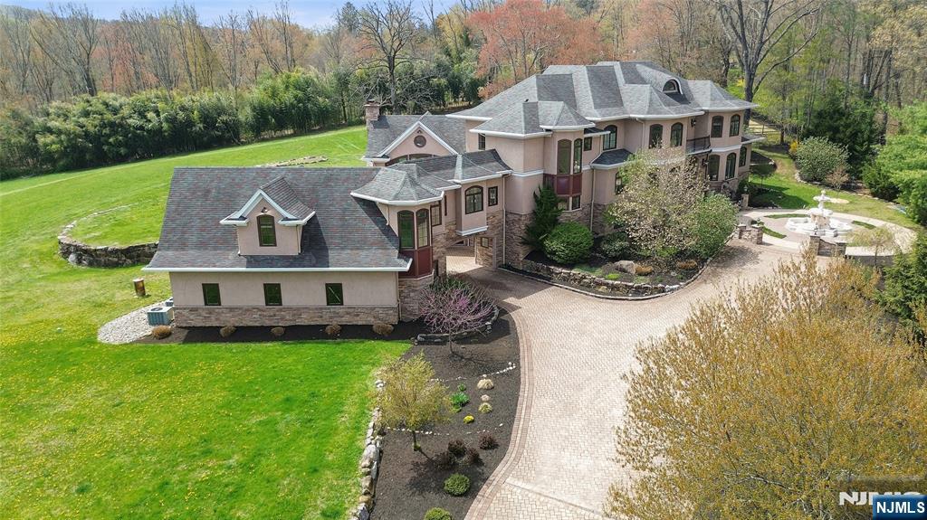 Stunning Custom Home. 6 Bedrooms, 7 Bathrooms and a complete In-law attached Apartment. Picturesque 6.7 acres, 6 car Garage and Private Pond. Brazilian Cherry Floors. The Chef's kitchen has Custom Cabinets, Sub-Zero Refrigerator and Freezer. JennAir Appliances include: 4 Cooling Drawers, 2 D/W, 2 Convection Ovens, Electric Stovetop and Microwave. Prep Island, Butlers Pantry and 3 Copper Sinks. Kitchen is open to the Great Room and DR. Great Room w/FP Leads to Bluestone Patio. LR Has Patio Access. Stunning 3 Story Grand Staircase. Primary BR w/Fireplace, 2 Dressing Rooms w/California Closet Systems, Bath w/Shower, sauna, 2 Vanities and Private Patio. Plus Attached Nursery and Powder Room leads to Main Floor Office. Laundry/Pantry off Kitchen. Private Apt connects with Private Hallway. Large Living Area, Full Bath and BR. Private Entrance and Garage Access. 2nd Floor has Jack n' Jill BR w/FB. Additional En-suite w/FB, 2 BR with Full Hall Bath and Laundry Room. 3rd Floor Loft has Murphy Bed. Basement Level is a Full Walkout from the Rec Room. Rec Room has a Full Bar, Fireplace, Wine Cellar and Full Bath. There is a Gym and a Large Theatre seats 10+. Mudroom with 6 Custom Cubicles Leads to Another 3 Car Garage. 7 Minutes To The Train, Close to Town and Lakes. Realtor.com rated Denville, NJ the best community friendly suburb in the U.S. in 2021.