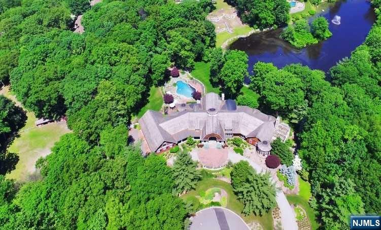 New Construction over existing foundation in 2006. Extra High ceilings and wide planked wood floors throughout. Amazing Woodwork and Moldings, all radiant heat...Enjoy the summer by the Infinity edge pool with waterfall or the hot tub! Five private acres on a double cul-de-sac. Custom Kitchen imported from England and installed on site. The Primary suite has a fireplace & huge walk-in closet, and the Primary Bathroom has dual vanities, spacious shower and separate soaking tub. Double French doors lead from the bedroom to the terrace with a fireplace and stunning view of the lake. Garden level has outside access, a huge unfinished area (in-law Suite) to design as you need! Potential for subdivision, 2 horses with corral, or could be tennis or plenty of cars!