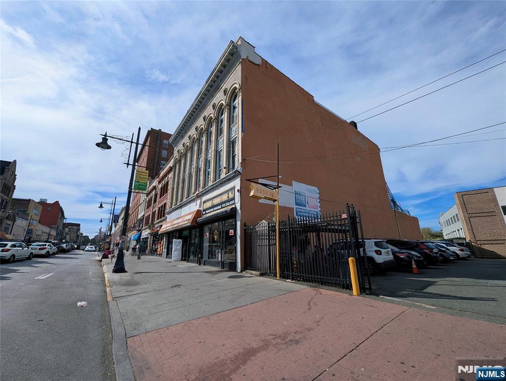 Rare opportunity to acquire a stabilized, income-producing commercial building in the heart of Paterson. Positioned on highly trafficked Market Street, this 3-story masonry asset offers approximately 13,107 SF of prime downtown real estate with immediate cash flow and long-term upside. The property features a leased retail storefront on the first floor (approx. 6,500 SF) and a leased office space on the third floor (approx. 3,500 SF), delivering strong in-place income. The second floor (approx. 3,500 SF) provides clear value-add potential for repositioning or future development. The property also includes rear land behind the building, offering additional expansion or build-out potential (subject to approvals). Located within the B-4 Central Business District zone, the property supports a variety of commercial and mixed-use uses. Based on zoning parameters and preliminary development concepts, there may be potential for residential conversion, with conceptual estimates ranging from approximately 40 to 90 units, subject to architectural design and full municipal approvals. Buyer to conduct independent due diligence with the City of Paterson. Surrounded by redevelopment, transit access, and established commercial activity, this asset offers multiple strategies: stable hold, expansion, repositioning, or long-term redevelopment.