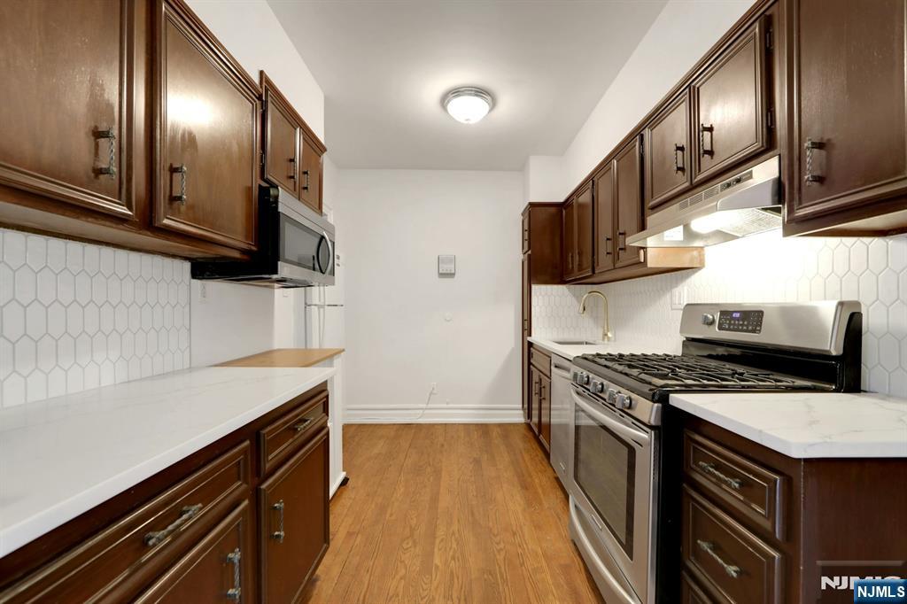 Located in Dwight Manor, this second-floor condo offers a bright layout with hardwood floors, updated finishes, and close proximity to local amenities. The spacious living room includes a wood-burning fireplace and large windows that provide natural light. An updated kitchen features stainless steel appliances, tile backsplash, and white countertops. Both bedrooms offer generous space and double windows. The full bathroom includes a tub/shower and classic tile. Additional features include radiator heat, window A/C units, tall ceilings, and an efficient floor plan with a defined dining area. On-site laundry, assigned outdoor parking, and elevator access add everyday convenience. HOA includes water, heat, hot water, common area maintenance, and trash removal. Approximately 0.1 mi to the NYC bus, 0.2 mi to Englewoodâ€™s shopping and dining district, 0.3 mi to grocery options, and 0.4 mi to nearby parks. Located near the center of town with access to major roadways and local services. Tenant Occupied.