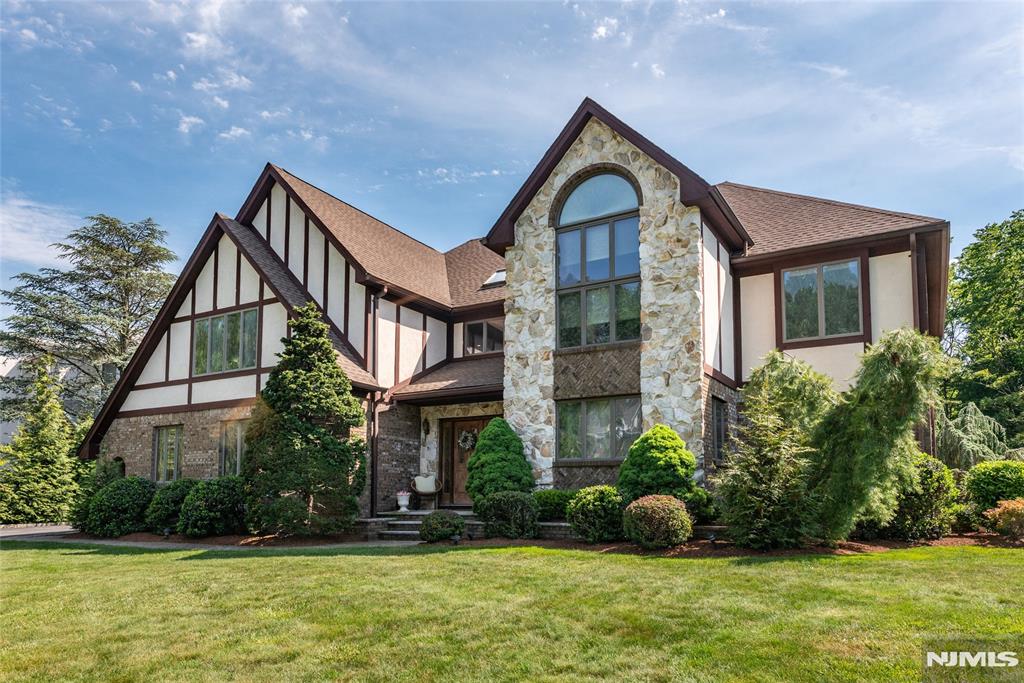 Beautifully maintained Tudor-style residence in the heart of North Caldwell, offering exceptional space, timeless character, and resort-style outdoor living. This impressive home features 4 spacious bedrooms on the second level, plus a first-floor office that can easily serve as a fifth bedroom.Inside, you'll find generously sized rooms highlighted by a dramatic floor-to-ceiling stone fireplace, soaring ceilings, and expansive windows that fill the home with natural light. The eat-in kitchen opens to the dining area, while a charming sunroom provides the perfect place to relax and enjoy views of the backyard.The home offers 3 full baths and 1 half bath, a finished basement with wet bar, and a partially finished walk-up attic currently used as an art studio, providing flexible space for a home office, playroom, or creative retreat.Outdoor living truly sets this property apart. The recently updated covered deck with skylights overlooks the beautifully landscaped yard and is ideal for entertaining. Enjoy summer days by the heated in-ground pool, gather with friends at the tiki bar, and appreciate the convenience of a pool cabana with its own full bathroom.Additional highlights include a 3-car garage and a roof approximately 5 years old. Combining classic Tudor charm with an exceptional layout and outstanding entertaining spaces, this North Caldwell home presents a rare opportunity to make it your own.