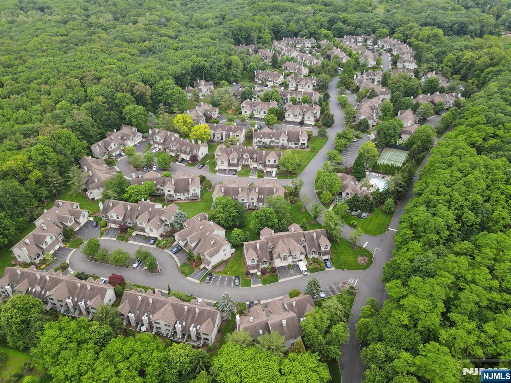 Discover modern elegance in the highly sought-after Northwoods Townhomes, one of Bergen County's most desirable communities. Step inside and be welcomed by an open, contemporary design highlighted by gleaming wood floors throughout. The stunning kitchen ideally located in the back, features custom high-gloss cabinetry, Quarts countertops, top of the line appliances, and a bright dining area overlooking a serene, private backyard - perfect for both everyday living and entertaining. Upstairs, a spacious hallway provides the ideal spot for a home office or cozy sitting area. The primary suite offers generous space to comfortably accomodate a king-size bed along with additional furnishings. Primary bathroom boasts double sinks, separate shower room and jacuzzi. Second bedroom is also spacious with high ceiling. Huge finished basement is finished and equipped with 1 bedroom, recreation room and a large storage room. Enjoy resort-style amenities right at home, including a clubhouse, exercise room, outdoor pool, tennis courts, and lush wooded surroundings. At Northwoods Townhomes experience the perfect balance of comfort, convenience and community.