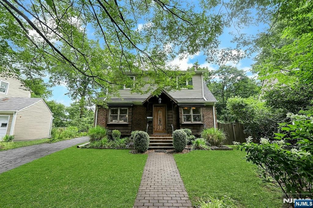A truly special 3BR, 2BA home bursting with character and craftsmanship. Inside you'll find rich wood details, a cozy wood-burning stove, spiral staircase, and a sun-drenched kitchen with granite counters and custom cabinetry flowing into a glass enclosed dining space. The finished basement adds a rec room, storage, and a relaxing sauna. Upstairs bedrooms offer creative built-ins and charming sloped ceilings. Baths include a vintage clawfoot tub and modern finishes. The lush backyard is fully fenced with a large playset, patio, deck, and privacy landscaping-ideal for entertaining. Hardwood floors, coffered ceilings, and handmade accents throughout complete this one of a kind storybook home that feels like a retreat yet is only moments away from NYC transportation, shops, restaurants, and houses of worship.