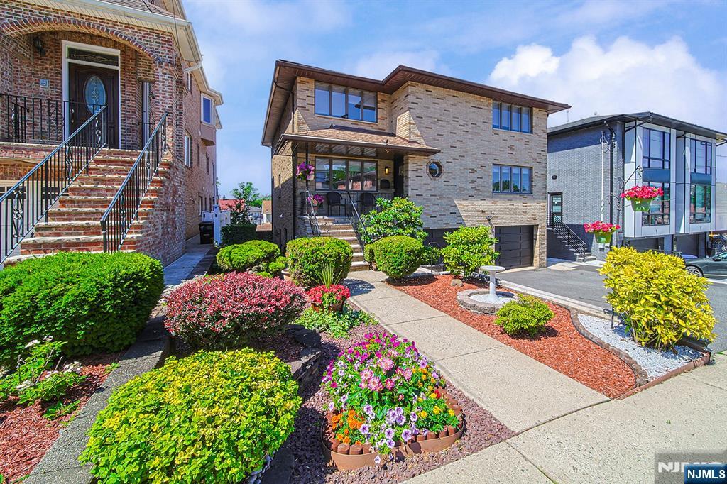 This exceptional, fully brick top-and-bottom two-family residence sits on an expansive 50x125 lot on a quiet, one-way street. Offering 3,216 square feet of pristine living space, the property features beautifully landscaped grounds and extensive recent upgrades. The second-floor unit is newly renovated and freshly painted, showcasing gleaming new hardwood floors through-out and a full suite of brand-new appliances. The ground level offers an ideal layout for entertaining, featuring a spacious family room with a wet bar and a woodburning fireplace. Sliding glass doors open to a private backyard, complete with a large deck. Perfect for investors or owner-occupants seeking rental income, the property is currently configured with the owner occupying the first floor and a tenant on the second floor generating $3,650 per month. 2 Car built-in garage and 3 car parking spaces on driveway.