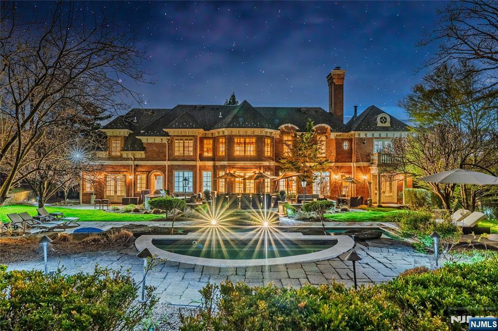 Perched high on the East Hill, this all-brick estate dazzles with sweeping sunset views and over 11,000 sq ft of refined living. A grand two-story foyer opens to warm, elegant interiors. Entertain in the banquet-sized dining room and chefâ€™s kitchen with double islands, high-end appliances, and sunny breakfast nook. The kitchen flows into a great room with coffered ceilings, fireplace, wet bar, and billiard room. The main level also features a private office, ensuite bedroom, and two powder rooms. Upstairs, the luxurious primary suite boasts vaulted ceilings, fireplace, spa-like bath, and multiple walk-ins. Four additional bedrooms offer ensuite baths, walk-ins, and high ceilings. The lower level is a dream: regulation indoor half basketball court, 11-seat theater, gym, and more. Outside, enjoy a private backyard oasis with heated pool, spa, and lush landscaping. Radiant heat throughout, full-house generator, and just 6 miles to NYC.