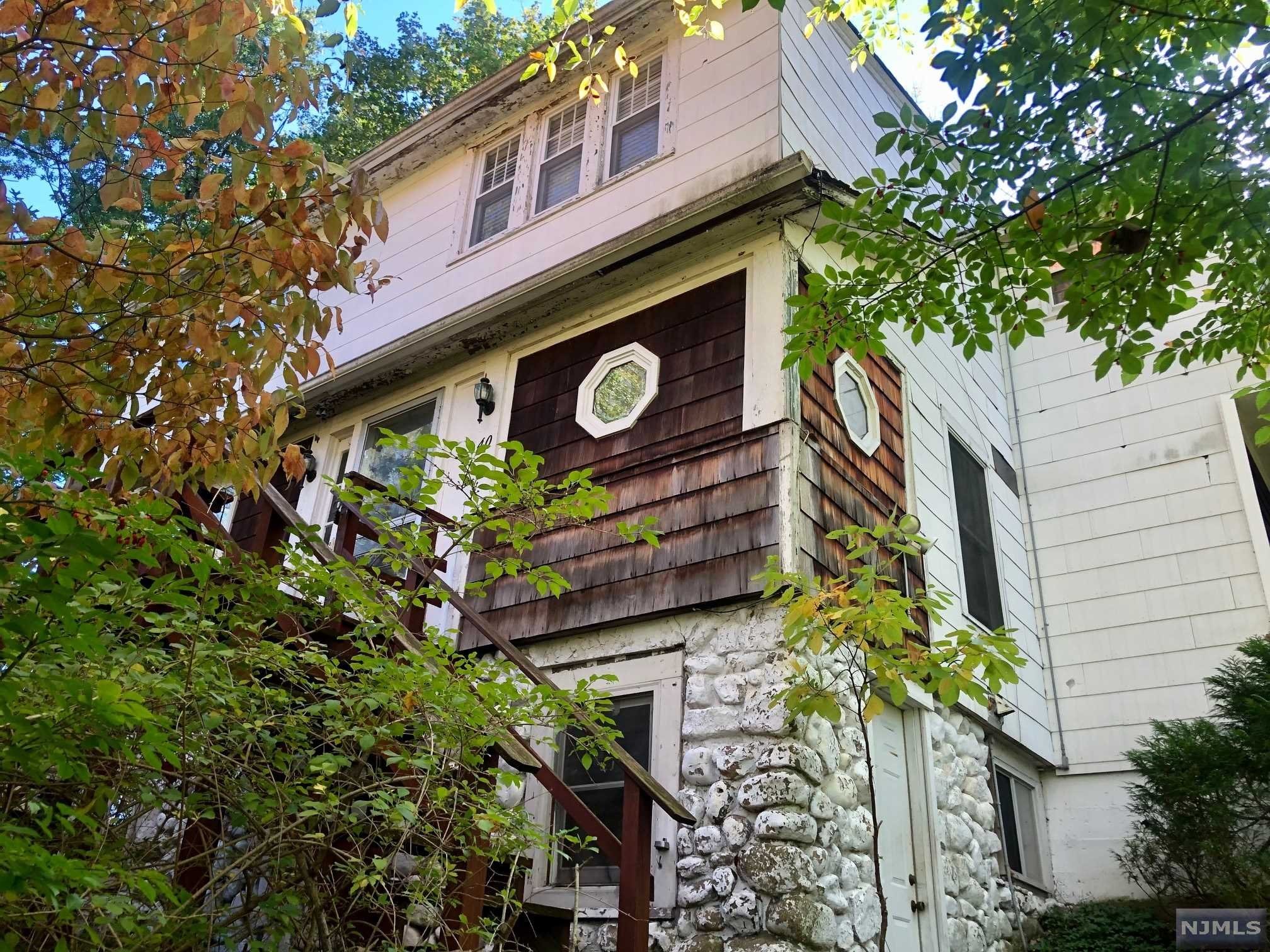 OPPORTUNITY AWAITS the creative buyer or builder in Ramsey! *CASH ONLY* *PROOF OF FUNDS REQ'D PRIOR TO SHOWING* Bring your vision to this 4BR, 1.5BA Colonial which dates to 1910. Built on top of a 19th century farmhouse, & situated on a private 1/3+ acre, you will immediately notice the extensive woodwork found throughout the home. The entry leads you to the foyer & living room. A sunroom is adjacent to the living room overlooking the front of the house. Continue thru to the dining room w/built-ins & to the adjoining kitchen with oak cabinets, tile floors & the back door leading to a maintenance-free deck. An add'l room off the foyer doubles as a library or office. Upstairs, you'll find 4 bedrooms, linen closet & a large bathroom. In the full, unfinished basement you will see the historical stone foundation. Plenty of privacy & storage including a shed out back. Newer Andersen windows on 1st floor, generator, stairlift, walk-in tub. Home being sold "as is".