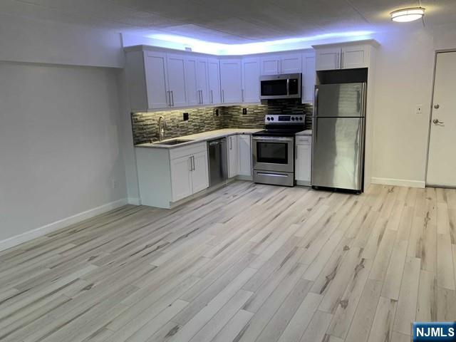 Light and Airy - Gut renovated (2020) 1 BR on 2nd Fl .- Elevator Building- Marilyn Manor. NYC bus & train nearby. Appears even larger than its 650 sq ft. Sunny Southwest Exposure. Bleached wood style floors throughout. Open concept - kitchen, living, dining .Shaker Style cabinets. Granite Counter Tops. grey brick back splash. Perimeter lighting under/above cabinets. SS appliances. 2 A/C units. Gorgeous Bathroom-All marble wall to ceiling. Grey tile floor. Stationary Glass door on tub. Large BR. W/D rm on floor. Listing Agent holds a NJ real estate license.