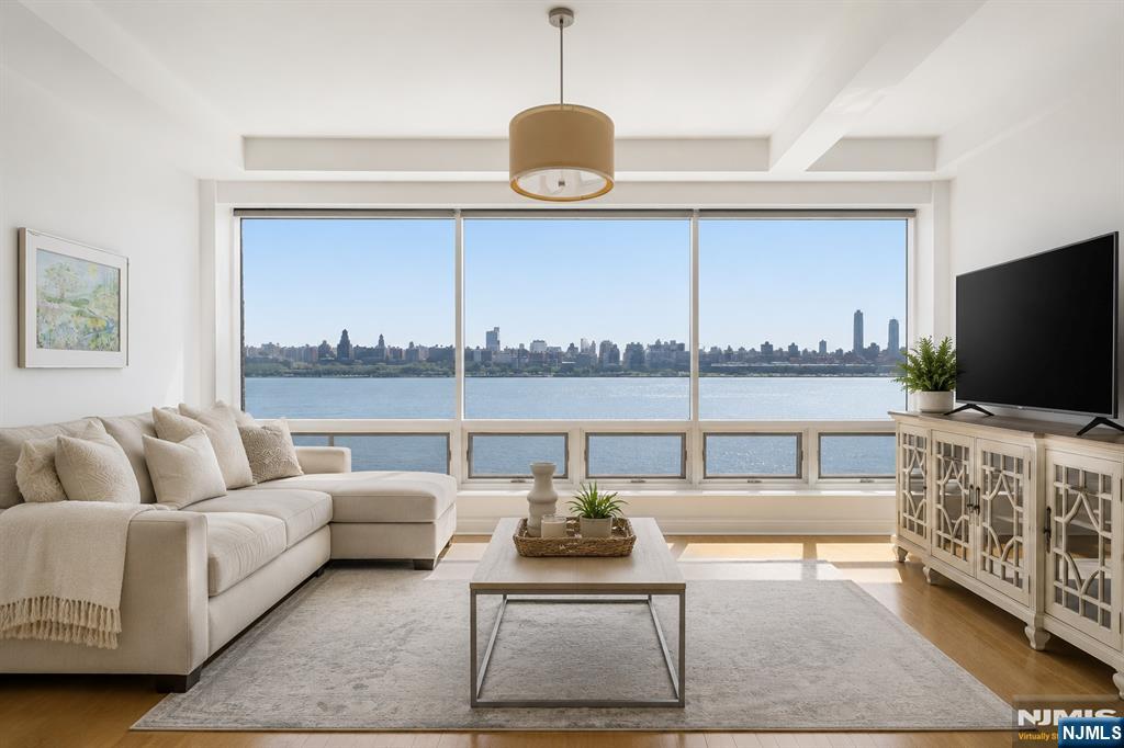 Welcome to The Pearlâ€”one of Edgewaterâ€™s premier waterfront buildings. This beautiful 1-bedroom, 1-bath home offers panoramic eastern views of NYC and the Hudson River. Featuring 10-foot ceilings, 8-foot doors, and natural hardwood floors throughout, the home flows into a spacious open-concept living, dining, and kitchen area with floor-to-ceiling windows showcasing incredible natural light and skyline views. Custom built-in closets and a chefâ€™s kitchen with top-of-the-line appliances make this home as functional as it is stylish. The bathroom features a sleek, spa-like design. Additional highlights include in-unit laundry and one assigned garage parking space. Full-service amenities include a 24-hour concierge, fitness center, outdoor heated pool, and roof deck. Conveniently located near restaurants, shopping, and everyday essentials including Whole Foods and Trader Joeâ€™s.