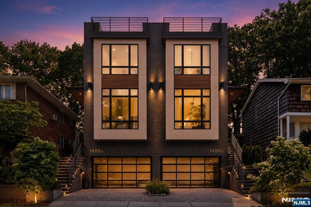 Rarely does a townhome offer this combination of luxury, privacy & location. Built in 2020 & better than new, this exceptional smart home sits directly across from a private wooded setting while offering beautiful NYC skyline views from its rooftop deck. Thoughtfully designed w/ rich hardwood floors throughout, timeless modern design & high-end finishes that create a truly upscale feel, the home features soaring ceilings, oversized windows & abundant natural light across multiple levels. The main level offers an open-concept layout featuring a spacious living room w/ fireplace, chef's kitchen centered around an oversized island, dining area, flexible sitting space, powder room, & access to a private fenced yard w/ patio. The 2nd floor includes 3 spacious bedrooms, laundry & a luxurious primary suite w/ large closets & a spa-inspired bath. The top floor serves as the ultimate retreat w/ a lounge area, wet bar, half bath & rooftop deck showcasing spectacular panoramic views. The ground level features a separate entrance, making it ideal for a home office, gym, recreation room, or guest space, along w/ a half bath & garage access. Conveniently located just minutes from downtown Fort Lee, the GWB, Rts 4, 46, I-95, & the Palisades Interstate Pkwy, w/ easy access to NYC transportation. Close to schools, shopping, dining, waterfront parks along the Hudson River, & scenic overlooks. This is a great opportunity to own a truly special home in one of Fort Lee's most desirable locations.