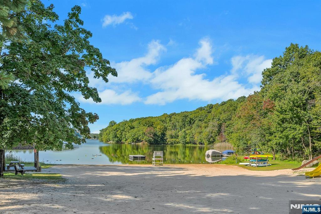 Lake views and mountain privacy come together in this 4 bedroom, 3 FULL bath Colonial set on over an acre in the desirable White Meadow Lake community. This home offers a private retreat-like setting with scenic surroundings and everyday comfort. The primary bedroom features beautiful lake views and access to a private balcony with a hot tub, creating a peaceful space to relax. The living room also overlooks the lake and opens to a second balcony. A spacious deck with a built-in gas line for grilling makes outdoor entertaining easy and convenient. The property extends up the hillside and is naturally low maintenance, with no regular yard work required. For those who want to take advantage of the full lot, the upper section can be selectively cleared to create a play area, walking paths, or a custom outdoor retreat. Interior features include two zone heating for efficiency and a walkout lower level with laundry, storage, and potential for future finishing. White Meadow Lake amenities include three beaches, 2 swimming pools, boating with electric and small motor boats permitted, fishing with stocked bass and trout, tennis courts, pickleball, a clubhouse with rental options, daycare, summer camp, a convenience store, pizzeria, and liquor store. The community offers an active lifestyle with year round activities. Convenient location approximately 35 miles to NYC and under 30 miles to Mountain Creek for skiing. Easy access to Routes 46 and 80 makes commuting simple.