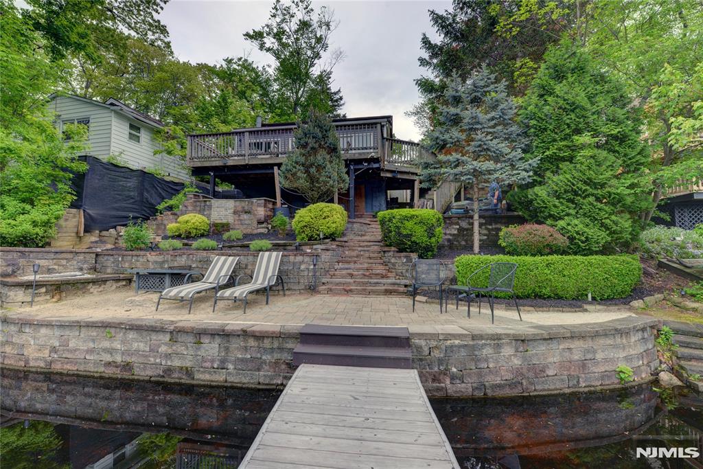 Stunning Renovated Lakefront Home â€“ Move-In Ready! Words can't do justice to this beautifully renovated lakefront retreat! Step into the inviting foyer, where you'll find a guest closet, with the spacious living room to the left and a gourmet kitchen to the right. The heart of the home is the fabulous eat-in kitchen featuring a large center island, granite countertops, and top-of-the-line appliancesâ€”perfect for cooking and entertaining. The entire home was fully renovated in 2023 and has been lovingly maintained since. The open-concept layout is enhanced by high ceilings and elegant laminate flooring throughout. The living room showcases custom, full-wall built-in cabinets with accent lighting and breathtaking lake views, framed by three expansive 6-foot sliding glass doors. Step outside to enjoy multiple tiers of outdoor living space, including a 30' x 12' deck, covered patio, fire pit area, and even a mini golf putting green. A private dock completes this incredible lakeside experience. Located just 7 minutes from downtown West Milford and Warwick, and only 2 minutes from Mountain Creek, this home offers the perfect blend of luxury, comfort, and convenience. If you're looking for a fully renovated lakefront property with serenity, style, and top-tier amenitiesâ€”this is it!
