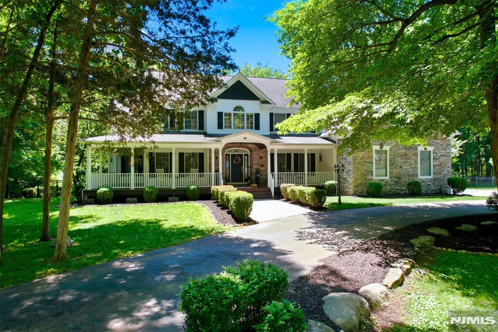 Located in the sought-after High Crest Lake section of West Milford, this exceptional custom estate offers approximately 7,200 structural sq ft on 5.35 private fenced acres. Designed for both everyday living and grand entertaining, the home features a dramatic two-story great room, private home office, home gym, and a designer kitchen with ceiling-height custom cabinetry, waterfall quartz island, premium appliances, and herringbone hardwood flooring. The luxurious primary suite offers vaulted ceilings, dual walk-in closets, a spa-inspired bath, and an attached sitting room. A ground-floor guest suite with full bath provides exceptional flexibility, while the fully renovated walkout lower level features a second kitchen, family room, bedroom, and new full bath with heated floors. Recent improvements include two new HVAC systems, two 100-gallon water heaters, renovated bathrooms, updated finishes, and extensive custom upgrades throughout. Outdoor amenities include a full-length deck, covered patio, wraparound mahogany porch, finished 3-car garage, horseshoe driveway, 21-zone irrigation system, generator hookup, multiple entertaining areas, and a stunning 12,000-gallon koi pond with double waterfalls. Optional High Crest Lake membership offers access to lake amenities and community activities. Just over 20 miles from New York City, this rare estate offers luxury, privacy, and space without compromise.