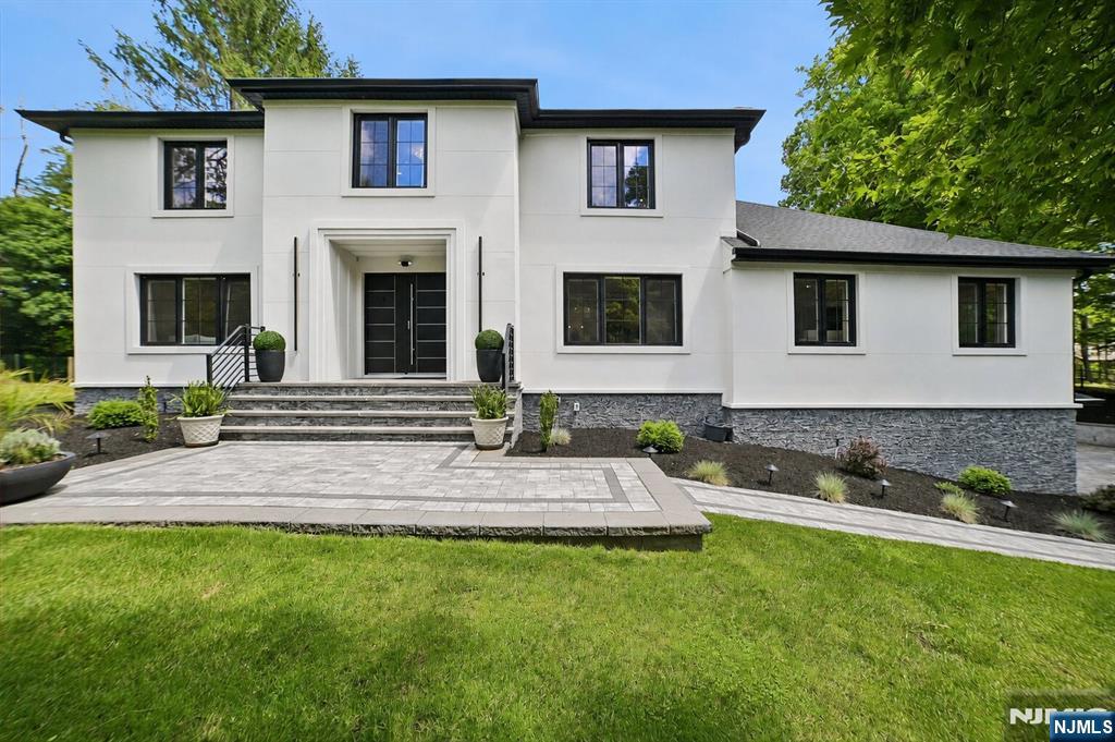 Welcome to this stunning custom home set on 1.79 private acres, offering luxury finishes, thoughtful design, and exceptional outdoor living. Renovated within the last three years, this 4-bedroom, 3-bath residence showcases designer tilework, custom details, and beautiful hardwood floors throughout the main level. A welcoming front porch leads into the foyer, flanked by a sun-filled office w/ large windows overlooking the front yard. The formal dining room is ideal for entertaining and flows seamlessly into the expansive living room. The kitchen opens to a spacious family room, creating a functional layout for everyday living and gatherings alike. A first-floor bedroom & full bath provide flexibility for guests, extended living, or a private workspace. Upstairs, a central skylight fills the second floor with natural light. The luxurious primary suite features a custom walk-in dressing room and spa-inspired bath with a soaking tub, rain shower, and dual shower heads. Two additional bedrooms & a full bath complete the level. The finished lower level offers a large recreation room and versatile bonus space. Outside, enjoy your own private retreat with a sprawling deck, additional patio, professionally landscaped grounds, and elegant exterior lighting. The heated saltwater pool with a waterfall serves as the centerpiece of the backyard oasis. Fully fenced & surrounded by mature landscaping, the property offers outstanding privacy, ample yard space, and an attached three-car garage
