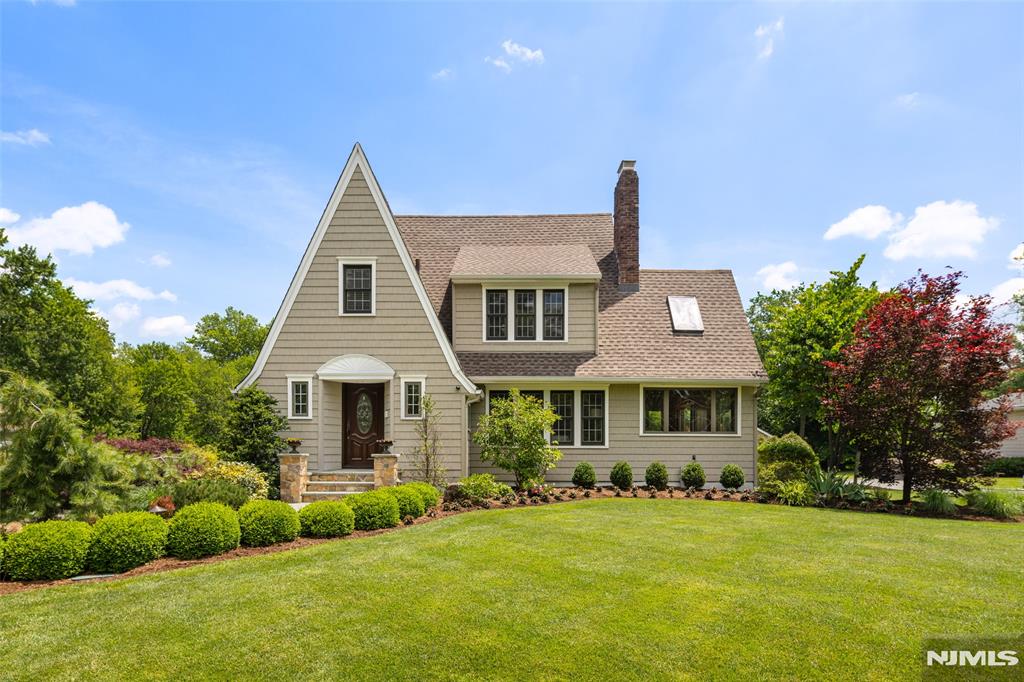 Set on a private, nearly one-acre wooded lot in the heart of Livingston, this beautifully expanded and meticulously maintained Tudor blends timeless charm with modern convenience. Sun-filled, open-concept living spaces feature hardwood floors, new recessed lighting, and a classic wood-burning brick fireplace. The gourmet kitchen offers custom cabinetry, granite countertops, under-cabinet lighting, and stainless steel appliances.The flexible floor plan includes a formal dining room, inviting sitting room with gas fireplace, and warm wood-paneled family room with skylights. A rare first-floor primary suite with private bath provides exceptional convenience, while the second level offers generously sized bedrooms. In total, the home features 5 bedrooms, 4 full baths, and 1 half bath.Two separate lower levels provide a finished recreation room, abundant storage, and utility space. Outside, enjoy a private backyard oasis with an in-ground saltwater pool with waterfall, diving board, hot tub, expansive deck with retractable awning, pergola, gas-line grill, koi pond, landscape lighting, underground sprinklers, and mature trees.Additional highlights include an oversized detached 3-car garage, extended driveway, central air, central vacuum, whole-house intercom, water softener, ceiling fans, attic exhaust fans, and generator hookup. Ideally located near Livingston schools, parks, shopping, dining, and NYC transportation.