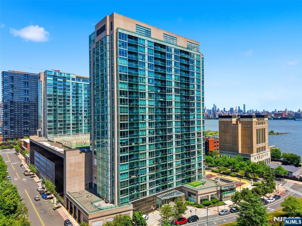 Luxurious 2-bedroom, 2-bath corner home with a den and private balcony showcasing beautiful NYC views, located in the sought-after community of 20 Newport Parkway. This residence has been completely renovated and has had only one owner. Enjoy a sleek, modern kitchen with new cabinetry and premium countertops, along with brand-new hardwood floors throughout. The spacious primary suite features a walk-in closet and an ensuite bath. A second bedroom, full second bath, and versatile den offer the perfect setup for a home office, guest space, or playroom. In-unit washer and dryer included. Full-service building amenities include 24/7 concierge, resident lounge, conference room, screening room, fitness center, jacuzzi, and a rooftop game room with breathtaking skyline views. Ideally located just minutes from the Newport PATH Station, Morton Williams supermarket, and Newport Mall.