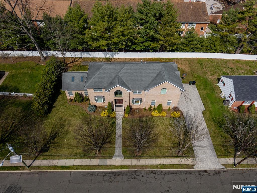 Stunning & grand center hall colonial with 4 bedrooms & 4.5 bathrooms. It features a 3 car garage and offers an extremely spacious and functional floor plan. The fully finished, amenity-packed basement was finished only 8 years ago and features two bonus rooms with closets(One is currently used as a gym). The main level welcomes you with a dramatic two-story entry foyer, flanked by formal living and dining rooms. A wet bar with beverage center and sink seamlessly connects the dining room to the kitchen, ideal for entertaining. The spacious kitchen features granite countertops, a breakfast nook, and opens to the expansive great room with vaulted ceilings and a gas fireplace. Upstairs, all bedrooms are generously sized with ample closet space. The primary suite is massive and offers two walk-in closets and a spa-like bath with a jacuzzi tub and oversized shower. A junior suite includes its own en-suite bathroom, while two additional bedrooms share a full hallway bath. A large laundry room completes the second level. Basement offers exceptional additional living space, including a large recreation room, bar, movie theater, gym, and a bonus room. Situated on a great property with a large deck and a flat, grassy backyard, this home offers both space and functionality. Ideally situated on a quiet cul-de-sac, walking distance to schools. Lot size is very large, approximately 12,824 sq ft. Paramus is known for top-rated schools, premier shopping, and a vibrant community.