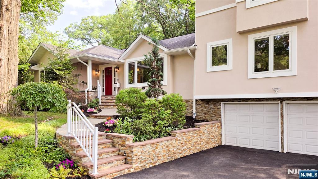 Experience the perfect blend of modern design, gut renovated in 2022 with exceptional craftsmanship and everyday comfort in this beautifully renovated 5-bedroom, 3.2 bath expanded ranch nestled on a picturesque half acre property on desirable East Hill of Tenafly! Designed for today's lifestyle, the open-concept floor plan is filled with natural light from oversized windows showcasing peaceful views. Elegant Italian tile flooring flows through the main living areas, complemented by tray ceilings in the living room, dining room, and primary suite. The first floor features a private wing with three generously sized bedrooms, two full baths, and a half bath. At the center of the home is a stunning chef's kitchen with an oversized quartz island, professional stainless steel appliances, abundant cabinetry, and generous prep space. The kitchen opens to the dining and great rooms, with sliding doors leading to a spacious deck overlooking the tranquil backyard and adjacent bedroom. The second-floor primary suite offers soaring ceilings, a walk-in closet, and a spa-inspired bath with a freestanding soaking tub and oversized glass-enclosed shower. A partially finished basement features new LVP flooring, recessed lighting, and an updated half bath. Outside, enjoy professionally landscaped grounds with sprinklers and a large backyard perfect for entertaining. This turnkey home is moments from Tenafly's renowned schools and express transit to Manhattan.