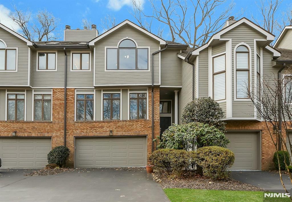 Beautiful 3-BR Townhouse in the Heart of Old Tappan! Step into this expansive and beautifully maintained home featuring gleaming hardwood floors throughout. The bright and inviting living room features a wall of windows and a dual-sided fireplace, creating a warm and airy atmosphere. The spacious dining room offers seamless indoor-outdoor living with sliding doors that open to a large deck with serene wooded viewsâ€”perfect for private outdoor living, entertaining, or relaxing. The updated eat-in kitchen includes white cabinetry, granite countertops, and stainless steel appliances. Upstairs, the luxurious primary suite features dual closets and a beautiful full bath with a double vanity and jetted tub. Two additional bedrooms, a full bath, and convenient laundry complete the second level. The finished walk-out lower level adds versatile living space with a bonus room/den, ample storage, and access to the attached two-car garage. Enjoy beautifully landscaped grounds along with fantastic community amenities, including a pool, clubhouse, and fitness center. Ideally located close to top-rated schools, parks, and shopping.