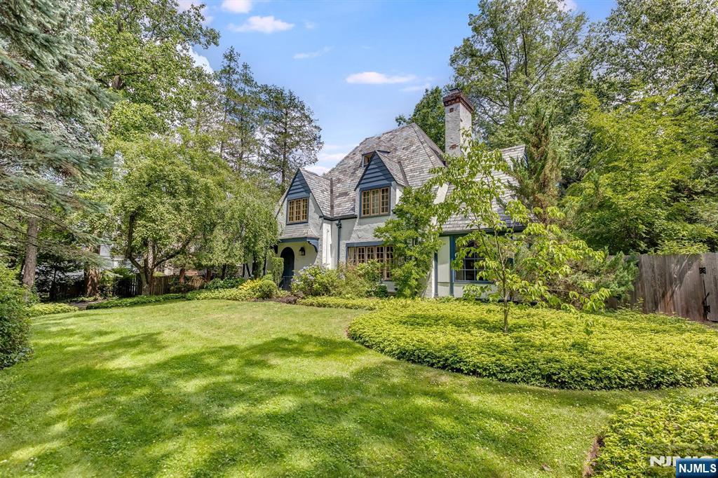 Welcome to your own hidden sanctuary. Nestled quietly away from the street in Glen Ridge, this enchanting French country cottage is an oasis of tranquility that feels worlds apart yet sits just blocks from everything you need. The magic begins at arrival, where a beautifully landscaped front yard leads to an elegant arched front door. Inside, a freshly repainted interior serves as a bright, sophisticated canvas for timeless architectural details. Unwind by the wood-burning fireplace in the living room, or retreat to the sunroom, a serene space featuring a second fireplace and marble flooring. The kitchen is well-appointed with a center island, granite counters, a Viking stove, and a sun-soaked breakfast room perfect for overlooking the patio and pool. Upstairs, the second floor hosts three bedrooms and two full baths, while the private third floor, with its own bedroom and bath, is an ideal space for guests or a quiet home office. Outside, the private backyard is a beautiful extension of the home. Enclosed by a tall fence and mature plantings, this quiet retreat features a heated pool. Combining modern peace of mind with storybook charm, this property is perfectly located near Linden Ave School, the local Jitney, and the Midtown Direct train to NYC. This is true Glen Ridge charm, designed for a lifetime of memories.