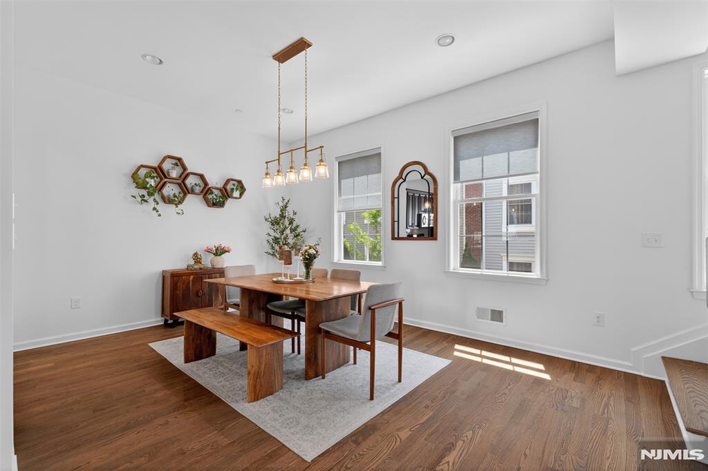 ***Call Charmy Morzaria at 609.619.2198 to see this home***Welcome to this Colonial-style townhome in the highly sought after Wright Place community of Wood-Ridge. Built just 7 years ago, this move-in ready home blends spacious living, modern design, and an unbeatable commuter location. Located approx 30 mins from NYC, w/easy access to major highways,NJ Transit buses, Wood-Ridge train station at 5 mins walk. A beautifully landscaped entrance welcomes you in to a thoughtfully designed floor plan. 1st level offers a versatile bedroom, full bath, ample closets, and direct access to the attached 2-car garage & driveway, ideal for guests/extended living/home office. The main living level features an open-concept design with soaring 10 ft ceilings, oversized windows, hardwood flooring, and abundant natural light. The modern kitchen has quartz countertops, stainless steel appliances, pantry, breakfast bar, and seamlessly flows into the spacious dining and living areas with access to a private deck, perfect for everyday living/entertaining. The upper level features a generous primary suite with dual closets, private bath,2 additional bedrooms, a full hall bath, and a conveniently located laundry. It also has dual-zone heating/cooling, a 2-car garage plus 2-car driveway, and beautifully maintained community courtyards. You are just moments from parks, restaurants, shopping, transportation, with HIGHLY RATED Catherine E. Doyle Elementary School located just a short stroll away.
