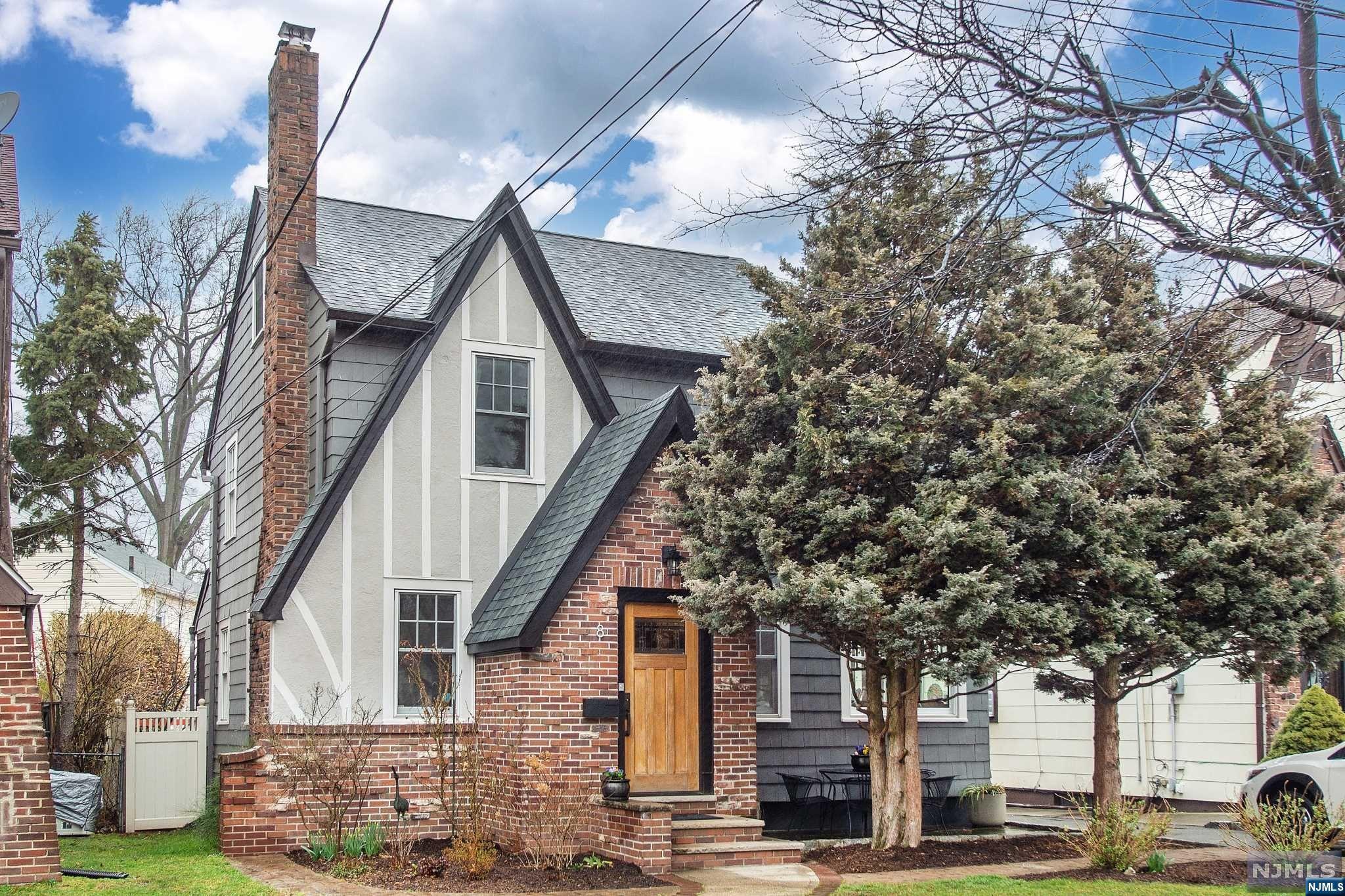 This sun-filled home has it all- old-world charm, prime location on a tree-lined street, and original, pristine craftsmanship. Cozy up in the living room, featuring a stunning brick fireplace and attached den/media room with blackout shades for movie nights. Original hardwood floors throughout, with ribbon detail in living room and dining room. Eat-in kitchen features SS appliances and attached powder room. Dining room leads to updated, screened-in porch overlooking the tranquil backyard with paver patio- perfect for those warm summer nights! The second floor boasts 3 bedrooms and main bathroom, while the third floor has endless potential- primary bedroom, WFH space, or zen room- you decide! Don't forget about the basement- a great space for a playroom or home gym, as well as plenty of storage, washer/dryer, and powder room. This classic Tudor, with contemporary living amenities, is more than just a house, it could be your new home.