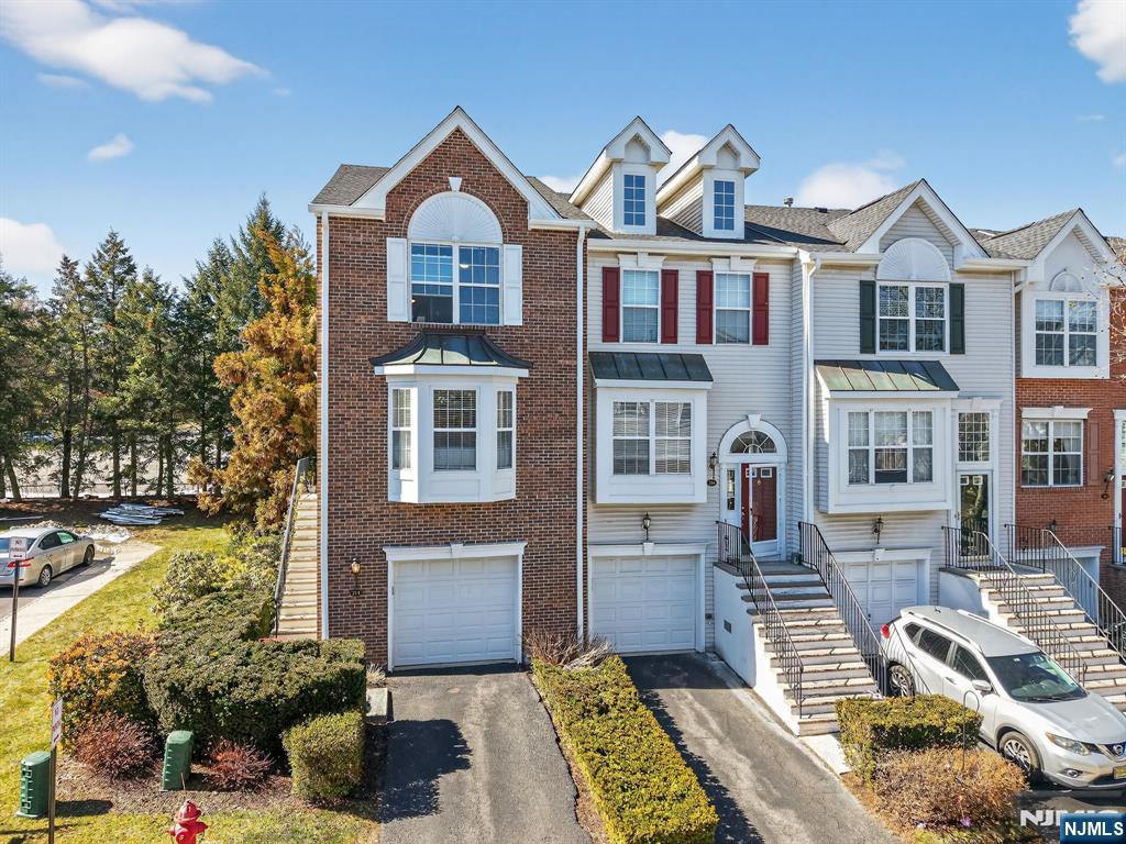 Welcome to this beautifully updated end-unit townhouse in the highly sought-after gated community of Cambridge Heights, offering 1,790 square feet of comfortable living space. Renovated in 2023, this move-in ready home features 2 spacious bedrooms, 2.5 bathrooms, soaring 9-foot ceilings, oversized windows that fill the home with natural light, recessed lighting, and beautiful Brazilian cherry hardwood floors throughout the main living areas. The updated kitchen is designed for both everyday living and entertaining, featuring granite countertops, abundant cabinetry, two pantries, and a convenient breakfast bar. The adjoining dining room showcases a cozy gas fireplace and the living room is spacious. Retreat to the impressive primary suite, complete with a beautifully renovated spa-inspired ensuite bath featuring Turkish marble tile, granite countertops, and two generous closets. The finished ground level offers exceptional flexibility as a family room, home office, guest suite, or gym, with direct access to the oversized attached garageâ€”larger than most in the community. Recent improvements include newer windows, a brand-new roof, a 2024 hot water heater, and a new AC system, providing added peace of mind for the next owner. Residents enjoy resort-style amenities: clubhouse, outdoor pool, tennis courts, fitness center, sauna, playground, and entertainment room. Ideally situated on a quiet cul-de-sac with easy access to highways, NJT, shopping and restaurants!