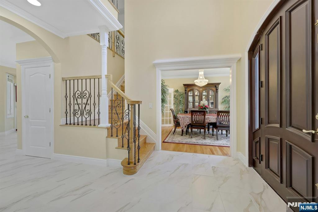 Taxes shown in Zillow is wrong. This beautiful house features 4 large bed, 4.5 bath, a well-appointed bright kitchen with granite counter tops, stainless steel appliances and tons of cabinets, an inviting formal dining room with French door, living room, family room with a cozy gas fireplace, coat closet, half-bath and breakfast nook all designed for seamless living. Enjoy the warmth of first floor and second floor rooms all with hard wood floors, crown molding and 4 bay windows facing front which bring abundant natural light to the home. New porcelain matt tiles laid out from entry foyer to the kitchen and to the half-bath add extra charm to the first floor.Step out onto the breath-taking tiled spacious patio complimented with beautiful balustrades, perfect for enjoying peaceful mornings or evening or entertaining guests creating endless possibilities for outdoor enjoyment. Gorgeous backyard is complete with an underground sprinkler system lawn, paver walkway and gas hook up for outside cooking. Upstairs, you will find an oversized master bedroom with a massive walk-in closet. The primary bath, which has new porcelain tile floor laid out in June 2025 features a walk-in glass door standing bath, jetted jacuzzi, dual vanities with marble countertop and a large closet. There are 3 additional bedrooms, each with ample closet place and two additional impeccable full baths and a laundry room. Full finished basement has a full bath & Central Vacuum System. Near to NY transportation