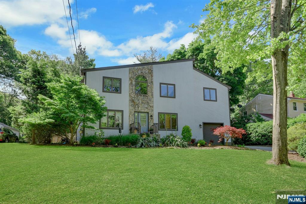 Welcome to this beautifully upgraded 3 bedroom, 3 bathroom contemporary home, perfectly situated on a level lot with exceptional landscaping and outstanding curb appeal. Designed for both comfortable living and elegant entertaining, this bright and inviting home is filled with natural sunlight throughout. The heart of the home is the open-concept kitchen, featuring stainless steel appliances, abundant cabinetry, and seamless flow into the living and dining areas. Rich hardwood flooring, recessed lighting, and tasteful updates create a warm yet sophisticated atmosphere. Retreat to the luxurious primary suite, highlighted by a vaulted ceiling that enhances the sense of space and tranquility. The spa-inspired primary bath offers a relaxing Jacuzzi tub, separate glass-enclosed shower, and dual vanity for ultimate comfort and convenience..Additional highlights include beautifully renovated bathrooms, generously sized secondary bedrooms, a spacious deck overlooking the landscaped grounds, and a fully finished basement providing versatile space for recreation, a home office, gym, or media room. Combining timeless Colonial charm with modern upgrades, this exceptional home offers the perfect blend of elegance, functionality, and everyday luxury.