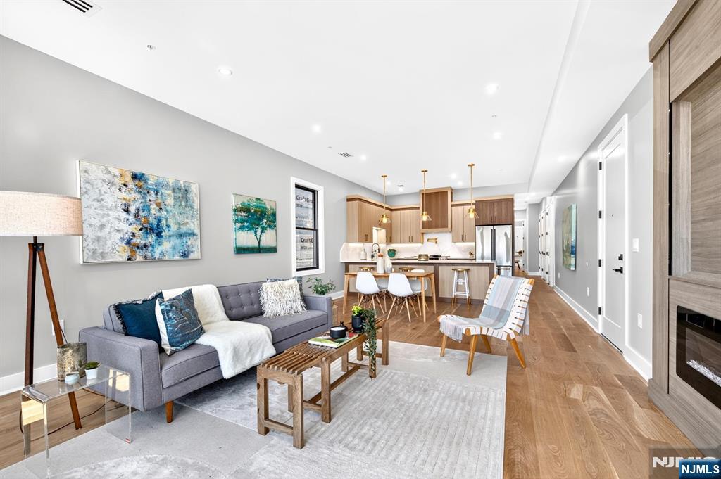 Welcome to 172 Griffith St, Unit 2, a beautifully designed 3-bedroom, 2-bathroom condo offering modern luxury in the heart of Jersey City Heights. Filled with natural light from oversized windows, the open-concept living and dining area features rich hardwood floors, a sleek electric fireplace with TV hookups, and seamless flow for everyday living and entertaining. The chef's kitchen showcases a stunning waterfall peninsula, two-tone cabinetry with black hardware, and premium GE Café stainless steel appliances, including a 6-burner range with optional griddle, pot filler, XO hood, built-in drawer microwave, and Frigidaire wine fridge. Thoughtful upgrades include custom hallway shelving, a Nest thermostat, central air, a high-efficiency Navien tankless water heater, and a full-size Samsung washer and dryer. The secondary bath features a floating vanity and deep soaking tub with a lighted niche. The spacious primary suite offers a custom walk-in closet and a spa-inspired ensuite with a floating vanity, rainfall shower, sliding glass enclosure, and illuminated niche. Enjoy your private balconyâ€”perfect for morning coffee, outdoor dining, or unwinding at the end of the day. Combining sophisticated finishes with modern comforts, this exceptional home offers elevated living in one of Jersey City Heights' most desirable locations.