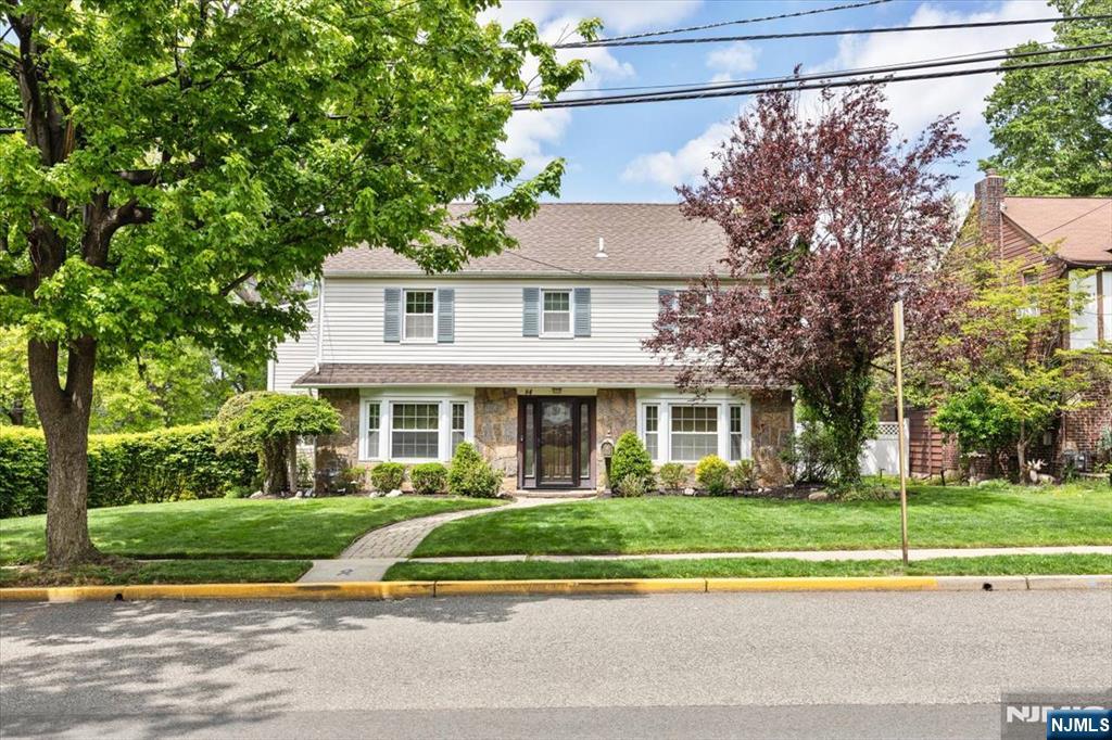 Tradition meets timeless style in this beautifully maintained Center Hall Colonial set on a picturesque tree lined corner lot. Filled with warmth, character, and thoughtful updates, this 3-bedroom, 2.5-bath home offers spacious living, classic details, and exceptional pride of ownership throughout. The inviting living room features hardwood floors and a woodburning fireplace, while the sun-filled all-season room/den provides the perfect space for relaxing, working from home, or entertaining year-round. The eat-in kitchen is equipped with St. Charles cabinetry, granite countertops, generous prep space, and an adjoining laundry/pantry area for added convenience. Upstairs, youâ€™ll find three oversized bedrooms, including a spacious primary suite with a walk-in closet and private bath. A second bedroom features an attached bonus sunroom ideal for a home office, reading nook, or den. Additional highlights include a full tiled bath with jacuzzi tub, walk-up attic storage, and a fully finished walk out basement complete with bar area, utility room, and direct access to the attached 2-car garage. Step outside to enjoy the beautifully landscaped property, private patio, and manicured yard perfect for outdoor entertaining or quiet evenings at home. Conveniently located near parks, shopping, schools, and transportation, this home blends classic charm with everyday comfort.