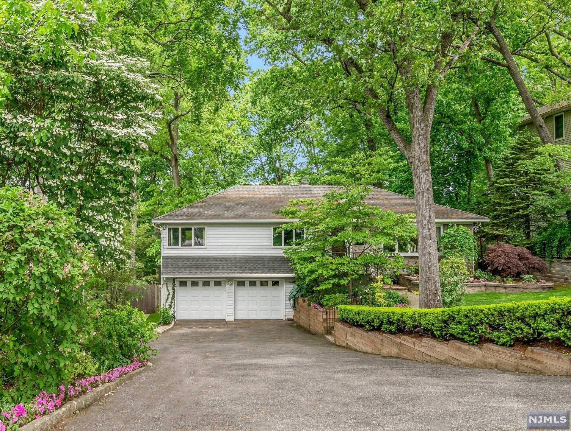 Nestled on an oversized park-like property in a desirable Fair Lawn location, this immaculate raised ranch is spacious, sun-filled, and beaming with curb appeal. Convenient one-level living with open flow, tall windows, and high ceilings throughout. Living room off the entry and formal dining room overlooking an updated eat-in kitchen with plenty of counter/cabinet space and center-island. At the heart of the home are an extra-large family room and second dining space with vaulted ceilings and floor-to-ceiling windows that overlook the serene rear yard. Spacious primary bedroom with custom closets and beautiful full bath. Two additional bedrooms and a hallway full bath complete the main level. Large finished basement offers an added living space, laundry room, powder room, entrance to the attached 2-car garage, and exit to the covered rear patio and completely private, fenced-in backyard. Minutes from transportation & major highways for commuting to NYC, shopping & restaurants.