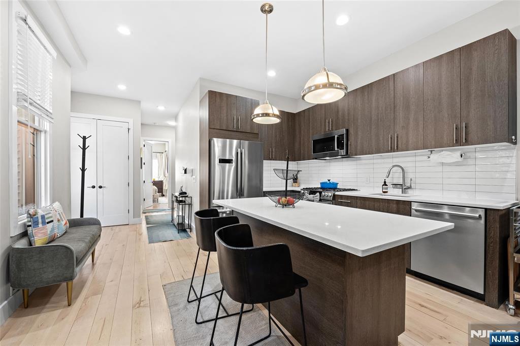 A standout duplex in the heart of Jersey City Heights, this fully reimagined home sets a new standard for modern living, complete with a private backyard. Thoughtfully renovated from top to bottom, the two-floor home pairs clean design with high-end finishes throughout. Wide-plank maple flooring, soaring 9.5â€ ceilings, oversized doors, and expansive Pella windows that fill the space with natural light, create an airy, inviting atmosphere. A spacious lower level provides flexible living, ideal for a home office, family room, or future third bedroom. The sleek kitchen features imported Italian cabinetry, quartz countertops, premium Bosch 800 Series appliances, and a built-in wine refrigerator. Enjoy the contemporary aesthetic of the three bathrooms, including a primary en-suite, each showcasing Hansgrohe fixtures and floating vanities. Smart home tech like the Nest thermostat, video intercom, and keyless Schlage entry offer convenience and peace of mind. Your living space extends outdoors with the private back yard; a rare opportunity for entertaining and relaxation alike. Ideally located, the home is a short walk from neighborhood staples like Washington Park, Riverview Park, the farmers market, coffee shops, fitness studios and more. With the local and NYC-bound bus lines less than a block away and the nearby 9th Street Light rail, take advantage of easy commuting while enjoying the quiet, residential feel of Webster Avenue. Parking available nearby for an additional fee.