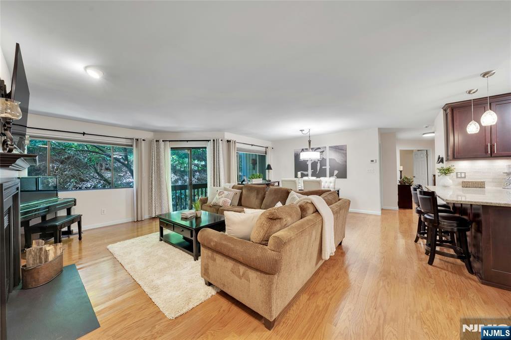 One floor living at its finest in Timber Valley!! A perfect blend of style, design and convenience in this beautifully maintained and rarely offered 2 bedroom, 2 bath unit designed for easy, modern living. A coveted one-car garage with bonus storage sets this unit apart, while gleaming wood floors and natural light create a warm, inviting vibe throughout. The living room with its wood-burning fireplace opens to a sunny dining area overlooking private, rustic views. The beautifully updated kitchen is a true standout, boasting stainless appliances, glass tile backsplash, extra-wide bar seating, pendant lighting, and a large walk-in pantry youâ€™ll absolutely love. Step outside to your own balcony retreat and enjoy the quiet peace. Down the wide hallway, you will find the primary suite with a generous walk-in closet, updated bath, and large window framing the year-round nature scenes. A 2nd bedroom with wood floors, a 2nd updated full bath, and a convenient laundry room complete this ideal floor plan. Head down to the oversized, customized garage and additional bonus storage room! With plentiful parking, a pet-friendly policy, walking paths, and sparkling pool, this community is built for enjoyment. Commuters will appreciate being less than a mile from the Route 17 train station, while Ramseyâ€™s charming downtown, top schools, dining, and shopping are all nearby. Best of all, the rear access offers only 3 steps to unit. Nothing to do but move in and start enjoying living carefr