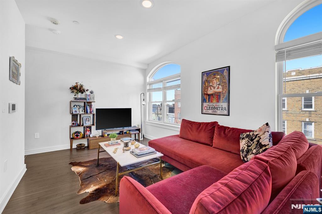 Modern duplex unit with parking and skyline rooftop in the vibrant section of The Heights in Jersey City, this sun-drenched duplex residence offers a perfect blend of space, light, and modern comfort. Oversized windows fill the home with natural light, creating an inviting and airy atmosphere throughout. The main level features an elegant open-concept living and dining area seamlessly connected to a stylish kitchen with a sleek quartz breakfast bar, ideal for entertaining or casual dining. Rich hardwood floors flow throughout the home, complemented by central HVAC with a Nest thermostat for effortless climate control. A full bathroom completes this level. The lower level offers two spacious bedrooms, a second full bathroom, and a convenient laundry and storage area, providing both comfort and practicality. Located just steps from Central Avenue and Journal Square, residents enjoy easy access to a dynamic mix of boutique shops, cafes, restaurants, and convenient transportation options to Manhattan. The building enhances the lifestyle experience with premium amenities, including a fully equipped fitness center and an impressive rooftop terrace showcasing breathtaking panoramic views of New York City Skyline.