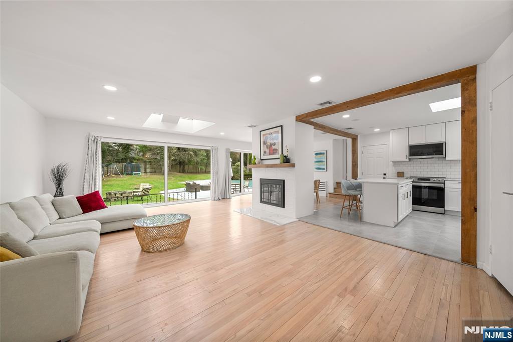 One-of-a-kind, serene, park-like property with a private backyard retreat featuring a pool and fire pitâ€”your own backyard oasis perfect for entertaining and everyday enjoyment. This beautifully updated ranch-style home offers 4 bedrooms, 4 full baths, and a 2-car garage. The main level features an open-concept layout connecting the living, dining, and kitchen areas. It includes 4 bedrooms and 3 full baths, a renovated kitchen, updated bathrooms, recessed lighting, refinished hardwood floors, and a dual fireplace. Oversized windows and skylights provide abundant natural light and backyard views. The lower level offers a separate entrance, family room, home office, full bath, and an additional room used as a bedroomâ€”perfect for extended living or guests. Ideal for growing families, multigenerational living, or hosting guests, with easy access to shopping, dining, highways, and an express bus to NYC less than a minute walk away.