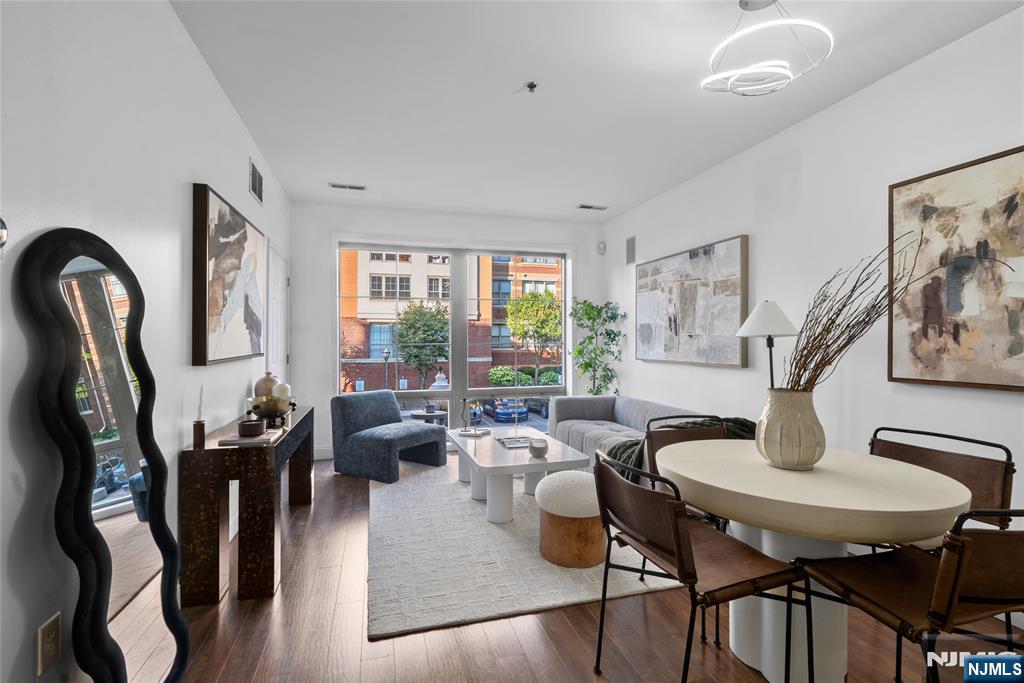 Discover the perfect blend of luxury and convenience in this pristine 1-bedroom, 1-bathroom condominium on the vibrant waterfront. Spanning approximately 740 square feet, this thoughtfully designed layout maximizes both style and comfort. Bathed in natural light, the living space features a stunning floor-to-ceiling south-facing window that brightens the entire home. Newer, beautiful wood-like flooring flows seamlessly throughout the living areas. The heart of the residence is an open-concept kitchen boasting gleaming granite countertops, premium stainless steel appliances, and generous cabinet storage. Retreat to the spacious primary bedroom, complete with a large walk-in closet and a well-appointed en-suite bath. For ultimate convenience, an in-unit washer/dryer and one dedicated parking space are included. Enjoy a true resort-style living experience. The monthly maintenance fee covers gas, water, parking, high-speed internet, and cable. Hudson Club is renowned for its top-tier amenities, offering access to a state-of-the-art fitness center, sparkling outdoor pool, clubhouse, concierge services, playground, and courts for tennis and basketball. Commuting to Manhattan is seamless with quick access to the NY Waterway Ferry and NJ Transit bus service to Port Authority. Everyday conveniences, including an ACME grocery store, Paris Baguette, local dining, and dry cleaners, are just moments from your door.