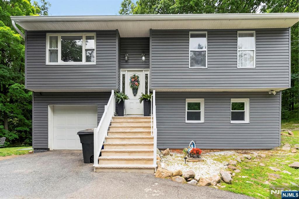 Only ten minutes from Barry Lakes, this majestic bi-level home offers the perfect blend of privacy, comfort, and natural beauty. Situated on almost three-quarters of an acre, this bright, clean, and pristine home is surrounded by mature pines, creating a stunning sun-infused setting with a peaceful, secluded atmosphere. The upper level features a beautifully updated kitchen with new appliances, that flows seamlessly into the dining area, where sliding glass doors open to a spacious deck overlooking the picturesque backyard perfect for entertaining or simply enjoying the tranquil surroundings. This level also offers a spacious living room filled with natural light, three generously sized bedrooms, and a full updated bathroom. The lower level provides additional living space with a large family room, a second full bathroom, a laundry room, and walk-out access to the backyard. Interior access to the attached garage adds everyday convenience. This property also has a new roof and a new septic system. The expansive driveway comfortably accommodates five or more vehicles, offering plenty of parking for any guests. This move-in-ready home combines modern updates, abundant living space, and a serene natural setting, making it the perfect place to call home.