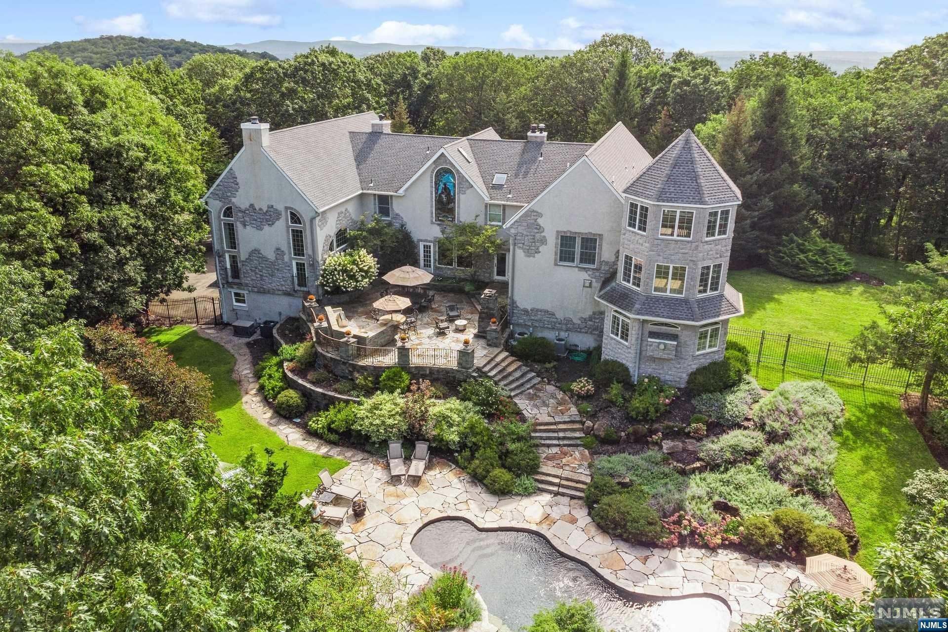 Perched atop ten acres this exceptional property offers the ultimate in sophisticated serenity. From the circular drive,step into grand foyer of this chaeteau inspired custom home and into your luxury lifestyle! The main level is punctuated by a grand ballroom w/ fireplace and soaring windows and ceilings with additional loft living room w/ fireplace. The kitchen features Wolf appliances, granite and quartz breakfast bar and powder room. The 1st floor also offers a cozy family room w/a wood burning stove and convenient powder room,along with a quiet den also with a fireplace and custom bar! The adjacent dining room provides an elegant space for any occasion.The 1st floor offers a guest bedroom with an ensuite bathroom,laundry room,and the 3-level primary suite w/ fireplace,walk-in closets and en suite bathroom w/ Jacuzzi,dual vanities and staircase to the second floor multi-purpose space and turret room. Two additional bedrooms,two w/ensuite bath, can be found on the second floor