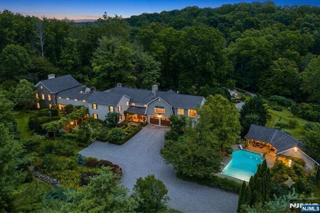 You cannot see Dove Island from the road. You may have already seen it in print. 40+ private acres in Sussex County, published in Great Houses & Gardens of New Jersey, held by one family since 1968, on land first farmed by the Westbrook family, among the earliest pioneers of this frontier. The 1890 farmhouse grew into a roughly 10,000 sq ft residence, redesigned by a Sag Harbor firm known for Hamptons estates. Stone, hand forged iron & deep wood run through the rooms. The two story great room rises around a monumental stone fireplace under a library that wraps the full second floor, & the kitchen is anchored by a cast iron British Aga. Down a gallery hall of lit museum cases sits a 19th century walnut paneled boardroom, dismantled on Wall Street & rebuilt here piece by piece. The primary suite holds dual dressing rooms, a fireplace sitting room & a spiral iron staircase to a hidden solarium under the primary bedroom. Beyond, a heated gunite pool & stone patios, a full pool house, tennis court, dual greenhouses, pond w/ bass, carp, catfish & koi, plus a climate controlled iron barn built to hold cars & collections. Multiple buildings & full generator infrastructure keep it running. The original farmland is ready for pasture, orchard or whatever comes next, w/ miles of equestrian & hiking trails close by. Estates like this are not built anymore. Multiple lots included. Shown by appointment only. Not currently farm assessed but can be, for significant savings.