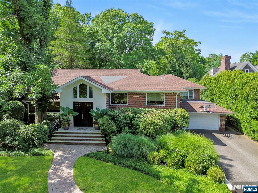 New Price Offering! Nestled on a quiet, tree-lined street, this beautifully maintained three-story split-level home offers the perfect combination of comfort, space, and location. Sitting on a stunning 1-acre property, the home provides generous outdoor space for entertaining, gardening, or simply enjoying the peaceful surroundingsâ€”all just minutes from the George Washington Bridge. Inside, the thoughtfully designed split-level layout offers a natural flow between living spaces and is filled with an abundance of natural light. The main level boasts a sunlit open-concept living and dining area adjacent to a beautiful eat in kitchen. Upstairs, youâ€™ll find an office and 4 bedrooms and two full bathrooms, including a massive master suite complete with a sitting area, walk-in closet, and luxurious en-suite bath. The lower levels offer a cozy family room, a game room, a guest suite with a full bath and a finished basement perfect for a home office, gym, or recreation room. Sliding glass doors open to a private backyard with a patio, ideal for outdoor gatherings. Additional highlights include a two-car garage and a prime location within walking distance to townâ€”enjoy the fabulous lifestyle that downtown Englewood has to offer, from boutique shopping and diverse dining to arts and community events. This property is a gem and not to be missed!