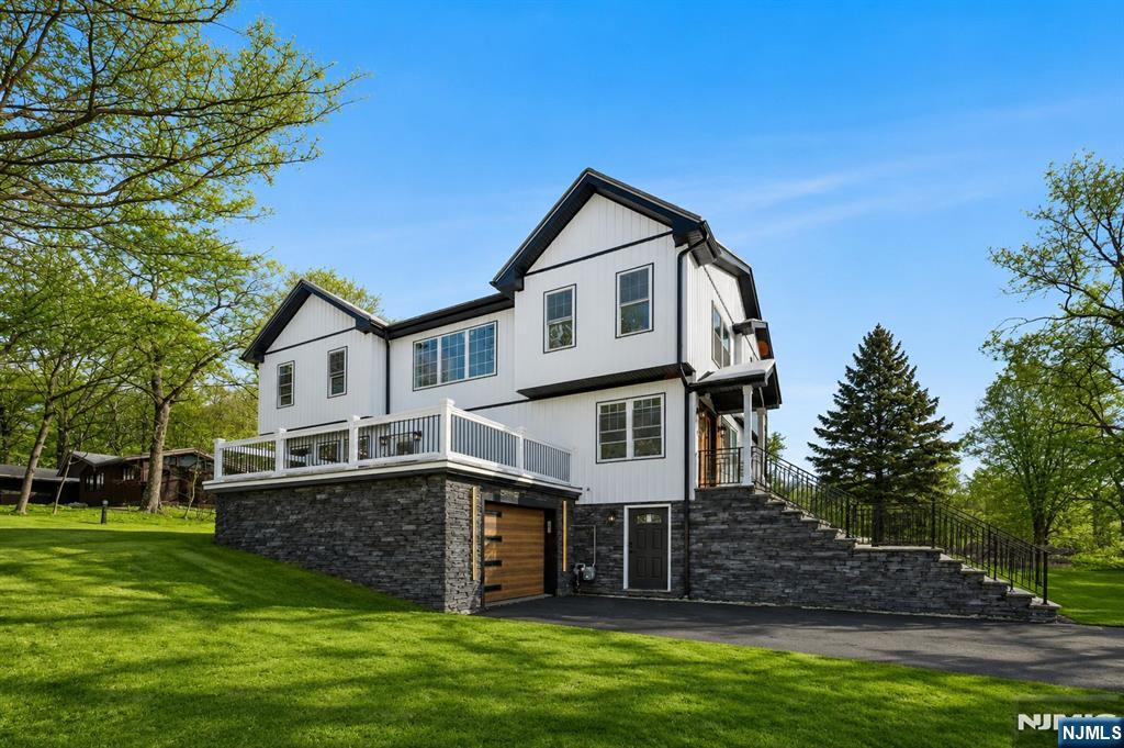 Welcome to this brand-new, top-to-bottom renovated residence offering over 3,000 square feet of living space, nestled in one of Woodland Park's most desirable neighborhoods and backing directly to the prestigious Garrett Mountain, with access to scenic trails and parkland.This exceptional home features 4 spacious bedrooms and 3.5 beautifully finished bathrooms, combining modern luxury with thoughtful design. The first floor offers an inviting living room, formal dining room, elegant powder room, and a gourmet kitchen with high-end appliances that opens to a backyard deck ideal for entertaining and enjoying the expansive, private backyard.The second floor showcases a tranquil primary suite with a walk-in closet, spa-like full bath, and a private balcony overlooking the natural surroundings. Three additional generously sized bedrooms and a full bath complete this level. The fully finished walkout basement provides incredible flexibility, featuring a large recreation room and a full bathroom perfect for extended living, guests, or a potential separate living space. Situated in one of the most sought-after neighborhoods in Passaic County, this home is conveniently close to transportation, schools, shopping, and dining, while offering the rare privacy and serenity of a mountain-back setting.A move-in-ready luxury home with space, style, and location this is one you don't want to miss.
