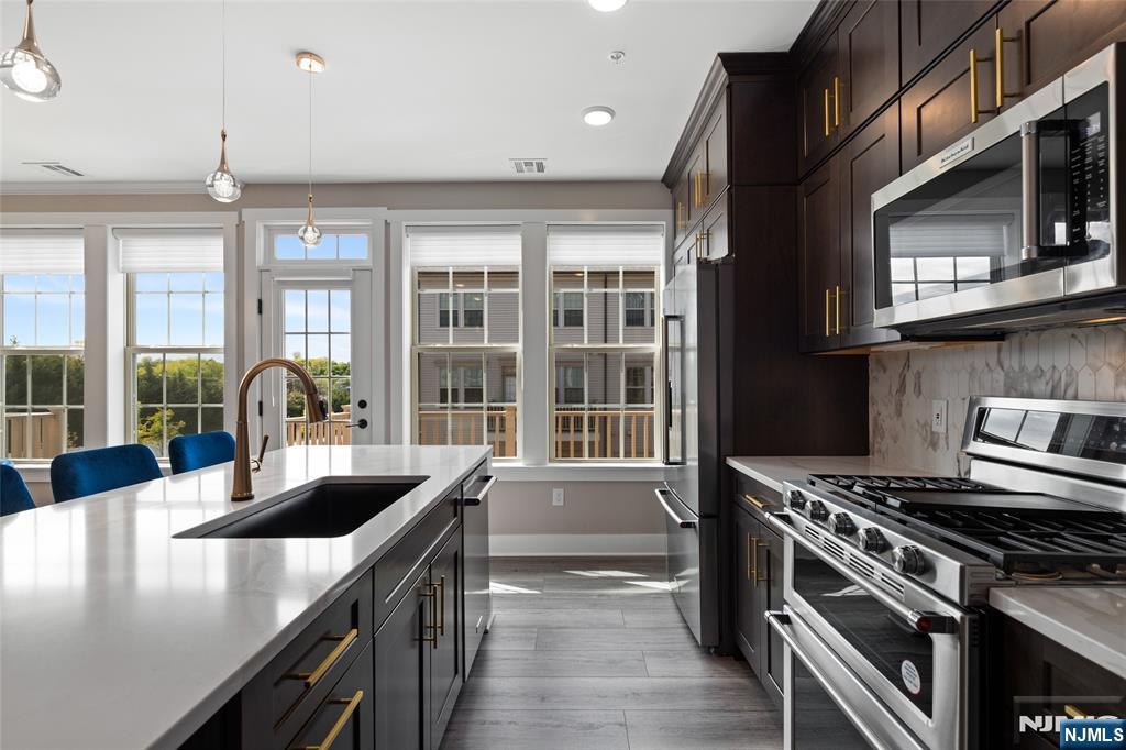 A beautifully upgraded 2 bedroom plus loft, 2 full and 1 half bath home located in the highly desirable LINK at Westmont. Built in 2022 & offering 1,771 SF of thoughtfully designed living space, enhanced w/ premium finishes & custom additions. The kitchen showcases higher-end KitchenAid appliances, a stunning marble backsplash, & elegant finishes that flow into a bright & open living area. Along w/ a balcony off the kitchen perfect for relaxing or grilling. Numerous improvements beyond the builder's standard features include vinyl flooring on the 2nd flr & stair treads, a built-out primary closet, high-end light fixtures, baseboard moldings, wainscoting, a mudroom bench, finished garage & a designer accent wall in the primary bedroom. Modern technology include a Ubiquiti network system w/ access points, Guardian managed security system w/ cameras & mechanical remote-controlled blinds. Builder upgrades from Pulte include an enhanced HVAC system w/ electronic air cleaner, zone dampener & humidifier, tray ceiling, luxury tile floors, tiled shower pan w/ built-in seat & soaking tub, double vanity guest bath & a garage hose bib. Offering valuable financial & long-term benefits; a tax abatement thru 2027 & a new construction structural warranty thru 2032, providing added peace of mind. Residents enjoy excellent amenities; guest parking, on-site shops, an athletic complex w/ baseball, soccer, pickleball, a dog park, playgrounds & close by tennis courts & Westmont Train Station.