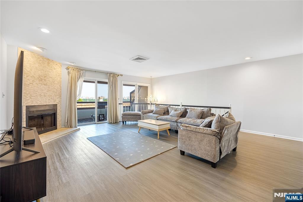 Welcome to this beautifully updated 3-bedroom, 2.5-bath condominium offering over 2,300 square feet in one of the area's most desirable gated communities. Ideally located just minutes from Edgewater's vibrant shopping, dining, waterfront, and major commuter routes, this home combines luxury, comfort, and convenience. The sun-filled open-concept living and dining area features newly installed hardwood flooring, a cozy corner fireplace, and sliding glass doors leading to a private balconyâ€”perfect for relaxing or entertaining. The oversized eat-in kitchen offers stainless steel appliances, abundant cabinetry, a farmhouse sink, and ample space for casual dining. The spacious primary suite includes dual closets and a private en-suite bath, while two additional generously sized bedrooms provide flexibility for family, guests, or a home office. Additional updates by the current owner enhance both style and functionality throughout the home. An in-unit laundry room and an attached two-car garage with a dedicated EV charging port add everyday convenience. Residents enjoy exceptional community amenities, including a heated outdoor pool with stunning NYC skyline views. Conveniently located near NJ Transit bus service, ferry shuttle connections, parks, restaurants, shopping, and the Edgewater waterfront, this move-in-ready home offers the perfect blend of luxury, space, and accessibility.