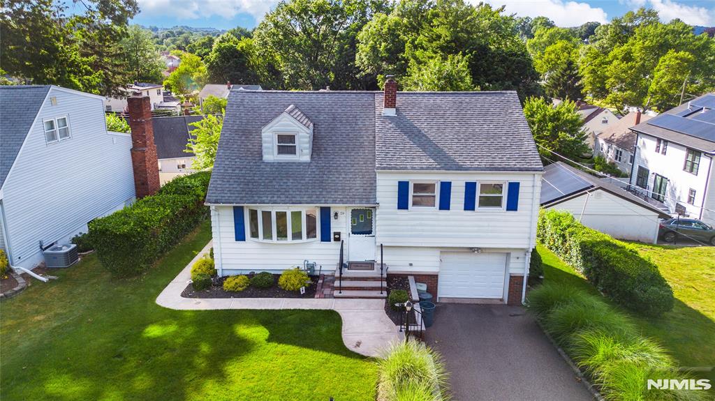 THIS IS IT! The perfect home in the perfect neighborhood! Tucked away on a residential street, this move-in ready home is waiting for you to unpack your bags and make it your own. Freshly painted interior and beautifully refinished hardwood floors make this home shine from the moment you walk in. Stunning curb appeal and manicured landscaping welcome you inside. The bright and inviting living room flows seamlessly into the dining room, creating the perfect space for everyday living and entertaining. The eat-in kitchen for every day meals. Upstairs, the second level features two comfortable bedrooms and a full bath. Escape to your private oversized third-floor bedroom, complete with easy access to a large attic for abundant storage. The partially finished lower level with half bath offers additional flexible space. A driveway leads to the attached garage with automatic opener for added convenience. Step outside and relax on the back deck overlooking the beautifully manicured yard. Newer heating unit, vinyl replacement windows and sprinkler system for easy lawn care. Enjoy central air conditioning on hot summer days! Ideally located with a path just steps to school and close to professional offices, transportation, NY train, major highways, shopping, restaurants, and more. A Must See!