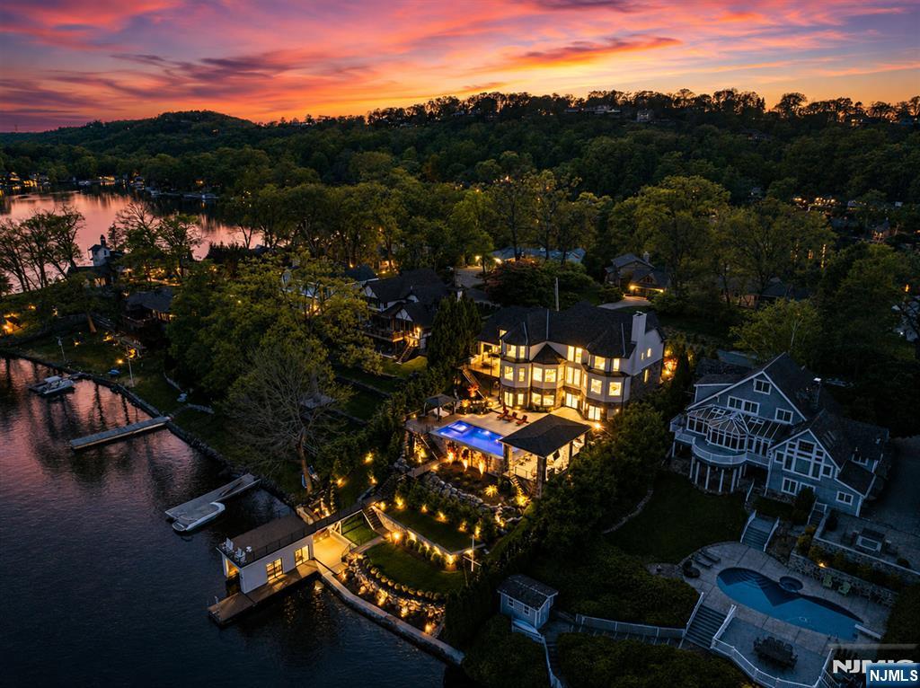 WATCH THE VIDEO! Set on prestigious Manitou Island, this renovated waterfront estate offers privacy & exceptional quality. This 5 bedroom, 6.5 bathroom home sits on a 19,798 square feet lot w/direct waterfront frontage & marina access. Completed in 2024, the home underwent a 2 year renovation, executed by elite professionals. The main level features soaring ceilings, Italian porcelain slab flooring, custom lighting & new Pella windows. A dramatic circular floating staircase w/wrought-iron detailing anchors the home, while 2 inline gas fireplaces add warmth. The chefâ€™s kitchen has new prep kitchen, butlerâ€™s pantry & premium appliances. The primary suite has 12-foot tray ceiling, gas fireplace, balcony, 2 walk in closets & spa-level bathroom featuring dual vanities, double shower, soaking tub & separate water closets. All bathrooms are equipped w/bidets. Backyard includes saltwater pool, hot tub, swim-up bar, 2 outdoor kitchens, televisions, cabana w/pizza oven, wine refrigeration, sink & integrated audio. A new concrete seawall protects the shoreline, while a new boathouse w/pontoon lift & included $60k pontoon completes the waterfront experience. Additional features include 3 level elevator, generator, new roof & septic system, natural gas conversion, spray-foam insulation, temperature-controlled 2 car garage, central vac, integrated audio, advanced security systems & municipal snow removal. A truly turnkey waterfront home where no detail, system, or finish was overlooked