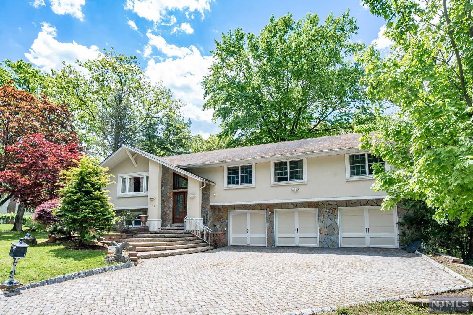 Situated on a quiet cul-de-sac, this oversized bi-level has it all! 4 bedrooms & 4 full bathrooms, plus an attached 3 car garage. Recently renovated kitchen with granite countertops, center island, SS appliances, and a beverage fridge. Large Living Room, Dining Room, and Family Room with sliding glass doors that lead to a HUGE TREX deck with a built-in grilling station. Massive Primary Suite with fireplace, Walk-in-Closet and spa-like Primary Bathroom that hosts a jetted tub, glass shower, and dual vanities. 2 additional bedrooms and bathrooms on this level (one is en-suite). Step down to the ground floor with an additional large family room with F/P, Summer Kitchen, and another bedroom and bathroom plus SGD to a covered paver patio. All of this on a Lushly Landscaped corner property with a large paver driveway, enough room to park multiple vehicles. Paramus is home to LOW TAXES and excellent schools. Easy access to NYC and shopping galore!