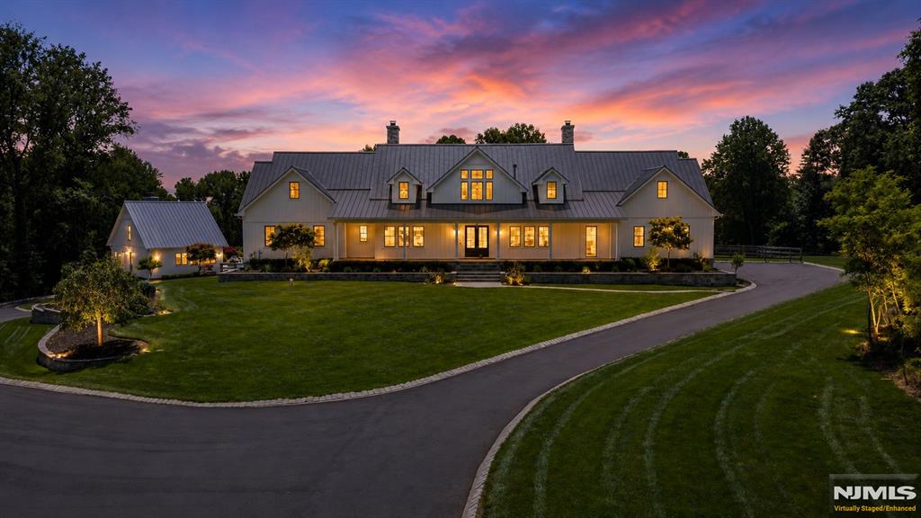 Welcome to Knightsbridge Estate. Set behind a gated entrance in Colts Neck's Clover Hill section, this approximately 15,000 sq ft modern farmhouse estate compound is designed for luxury living, entertaining, wellness, equestrian pursuits, and animal-property use. The residence offers 7 bedrooms, 8 full baths, 3 half baths, soaring ceilings, black-framed windows, radiant-heated floors, a 3-level elevator, sauna, gym, wine room, smart home system, generator, solar, and 5 fireplaces. The primary suite serves as a private retreat with a spa-inspired bath. Outdoor amenities include an in-ground pool, pond and water views, trails, dog wash room, fenced dog run, and expansive open acreage. A fully equipped 1950s-inspired casita includes an eat-in kitchen, bedroom, and full bath, providing separate guest accommodations. A 5-stall barn supports equestrian and animal-property use. A detached building currently configured as a dance/yoga and wellness studio offers flexible use and may be converted back to a 6-car garage. A rare offering combining acreage, equestrian facilities, guest accommodations, wellness amenities, and smart-home technology in Colts Neck.